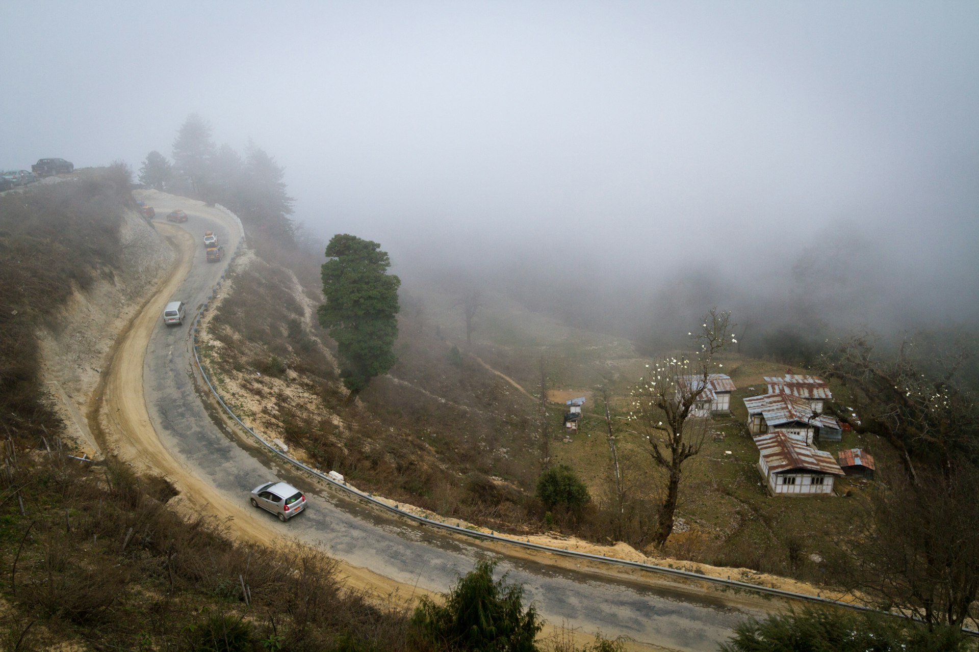 A winding road to Dochu La Pass on a misty day, Bhutan