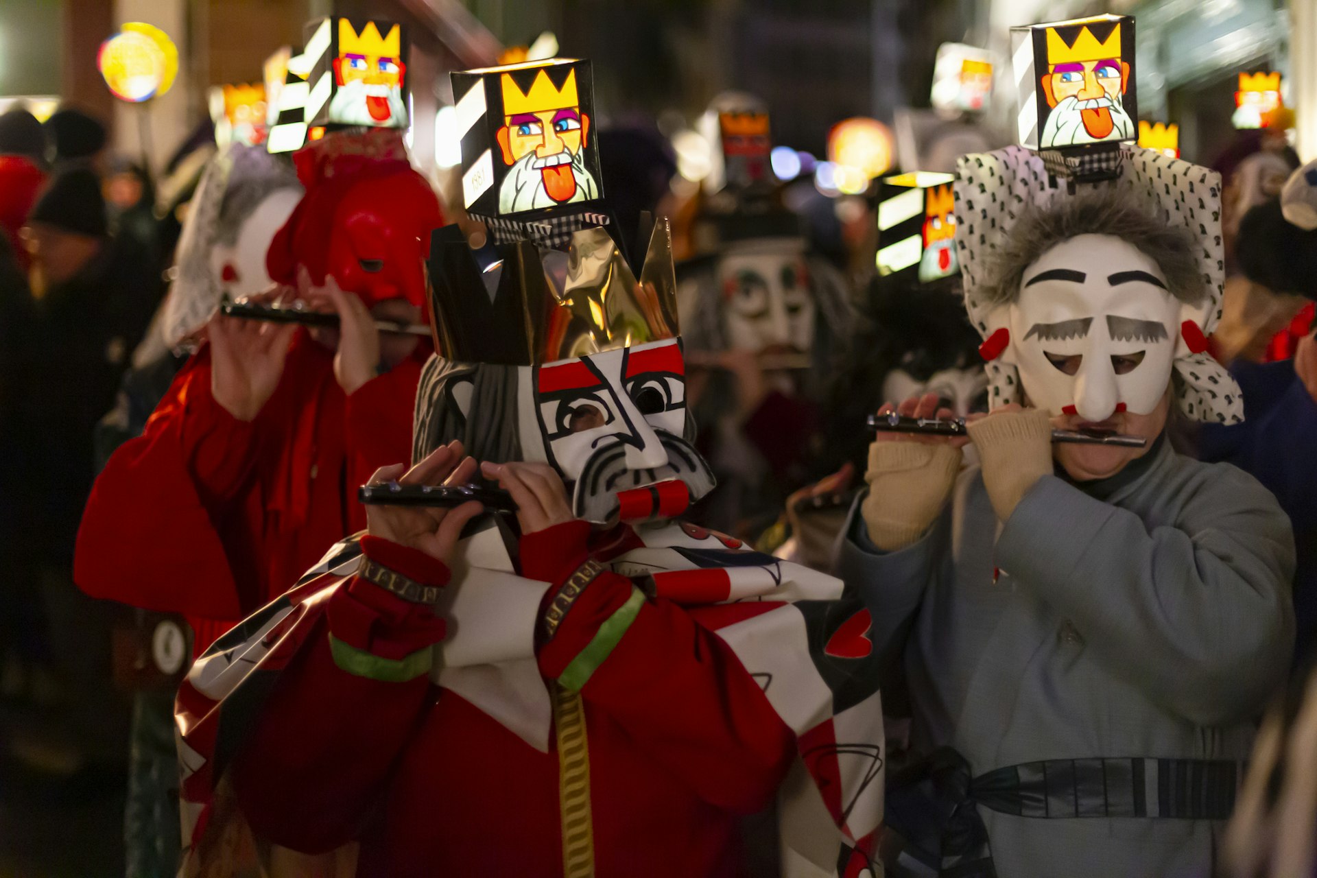 Close-up of piccolo players in their costumes with illuminated head lanterns at Fasnacht in Basel, Switzerland