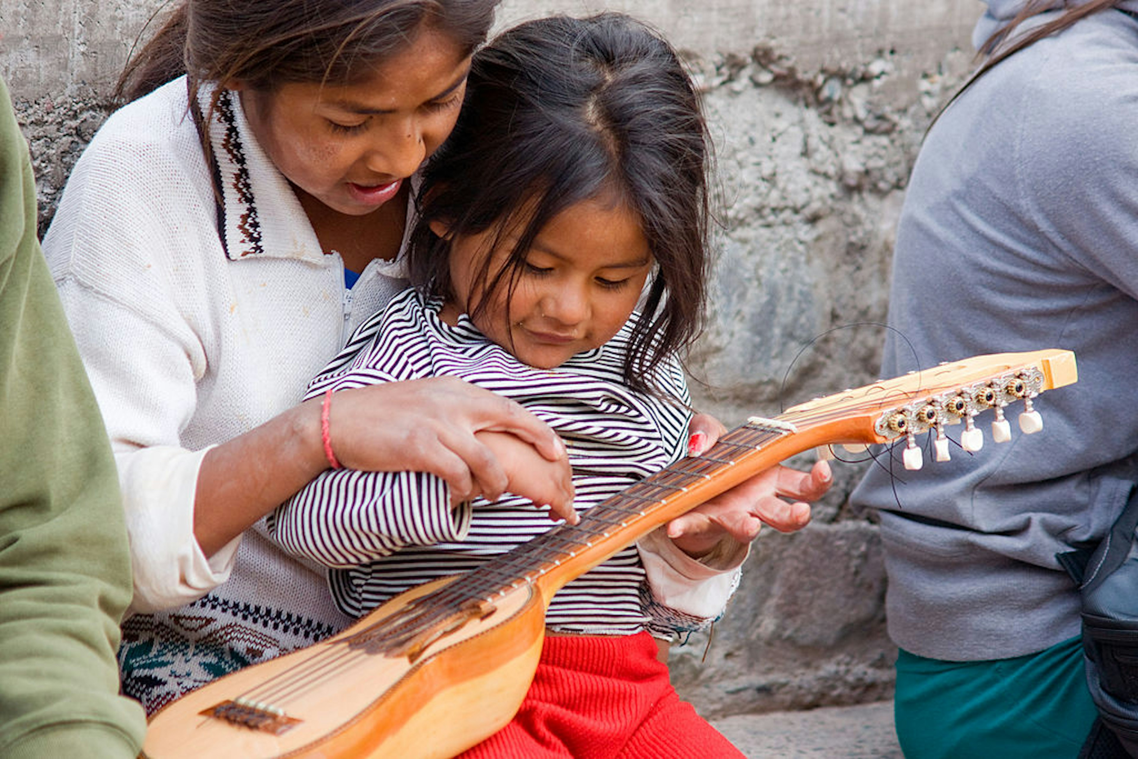 Little Quechua girls are playing with a charango, an Andean lute instrument in Iruya (Argentina) a remote village in the Quebrada de Humahuaca, in Northern Argentina