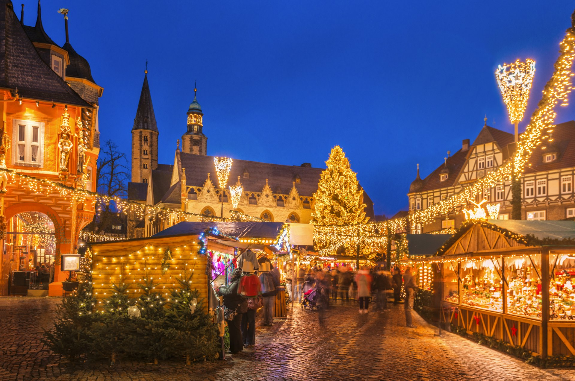 The traditional Christmas market on the historic Market Square in Goslar, Germany at dusk.