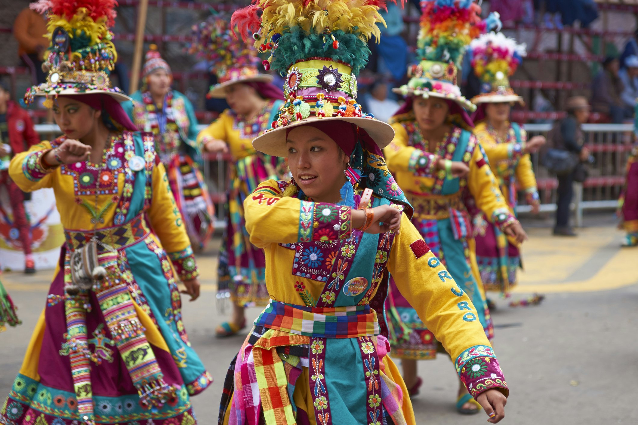 Dancers in patterned colorful clothing at a street parade.