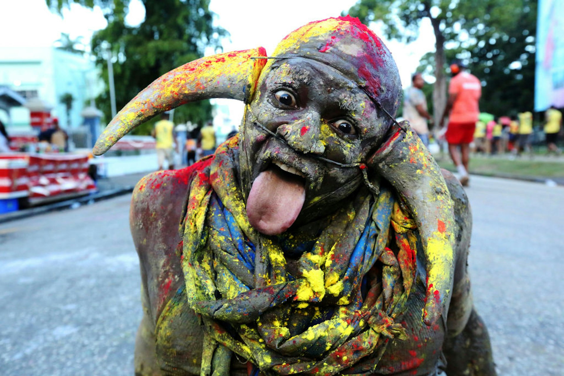 A carnival reveler with his face covered in paint and wearing horns poses for a portrait during the J'ouvert street procession as part of Trinidad Carnival