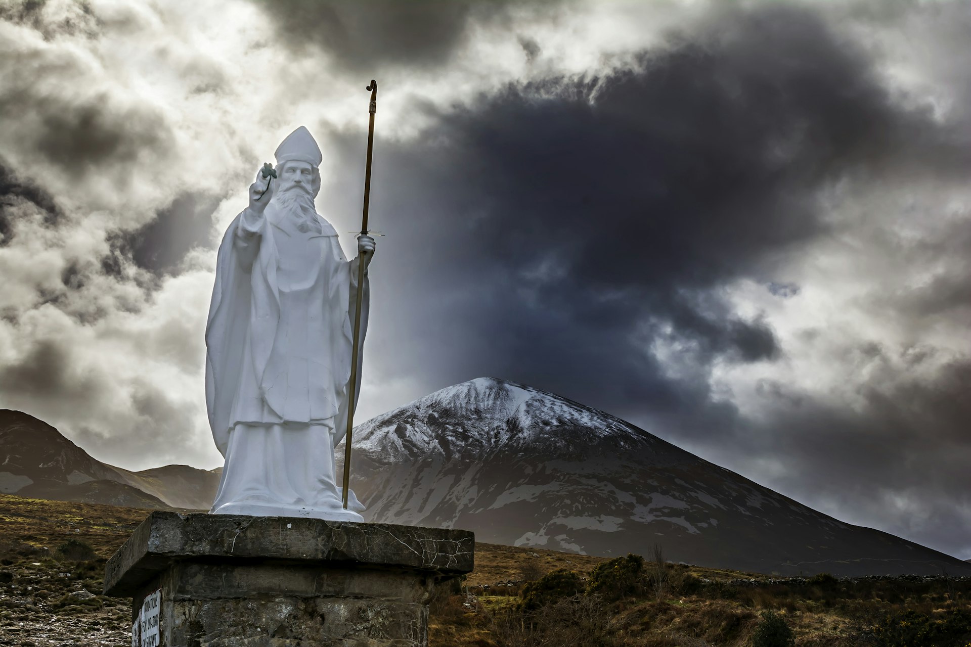 Uma estátua de São Patrício fica em frente a Croagh Patrick, apelidado de Reek, é uma montanha de 764 metros e um importante local de peregrinação no condado de Mayo, na Irlanda.