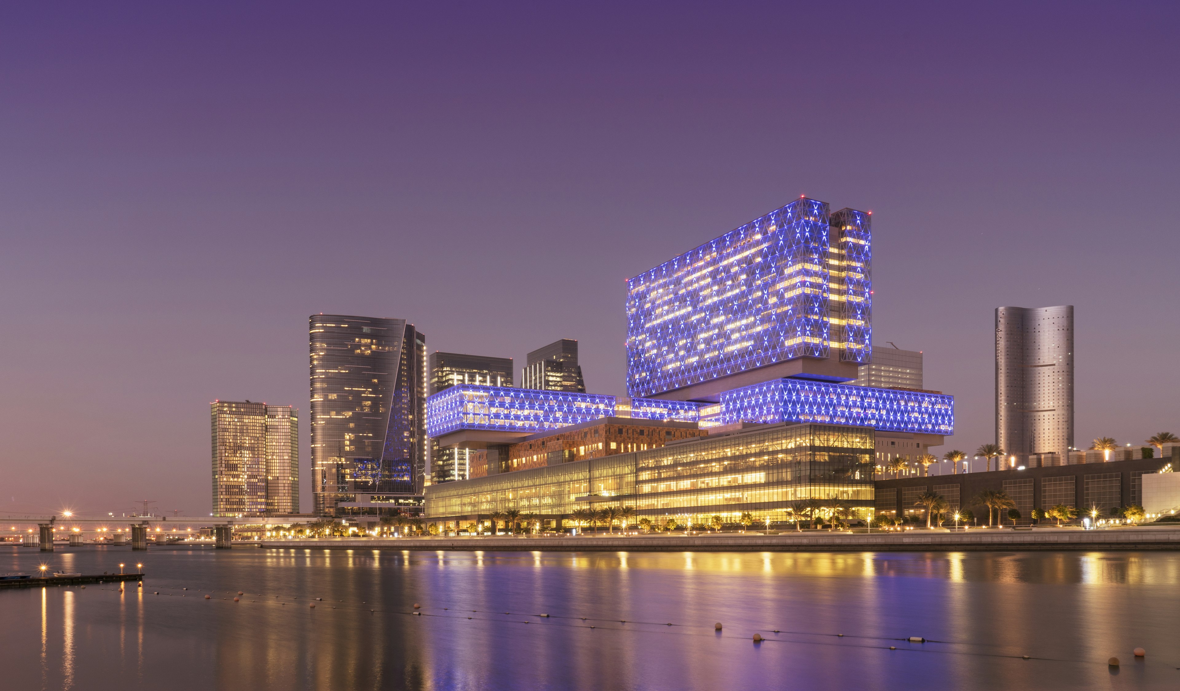 Modern buildings on Al Maryah Island (formerly known as Sowwah Island) lit up at dusk