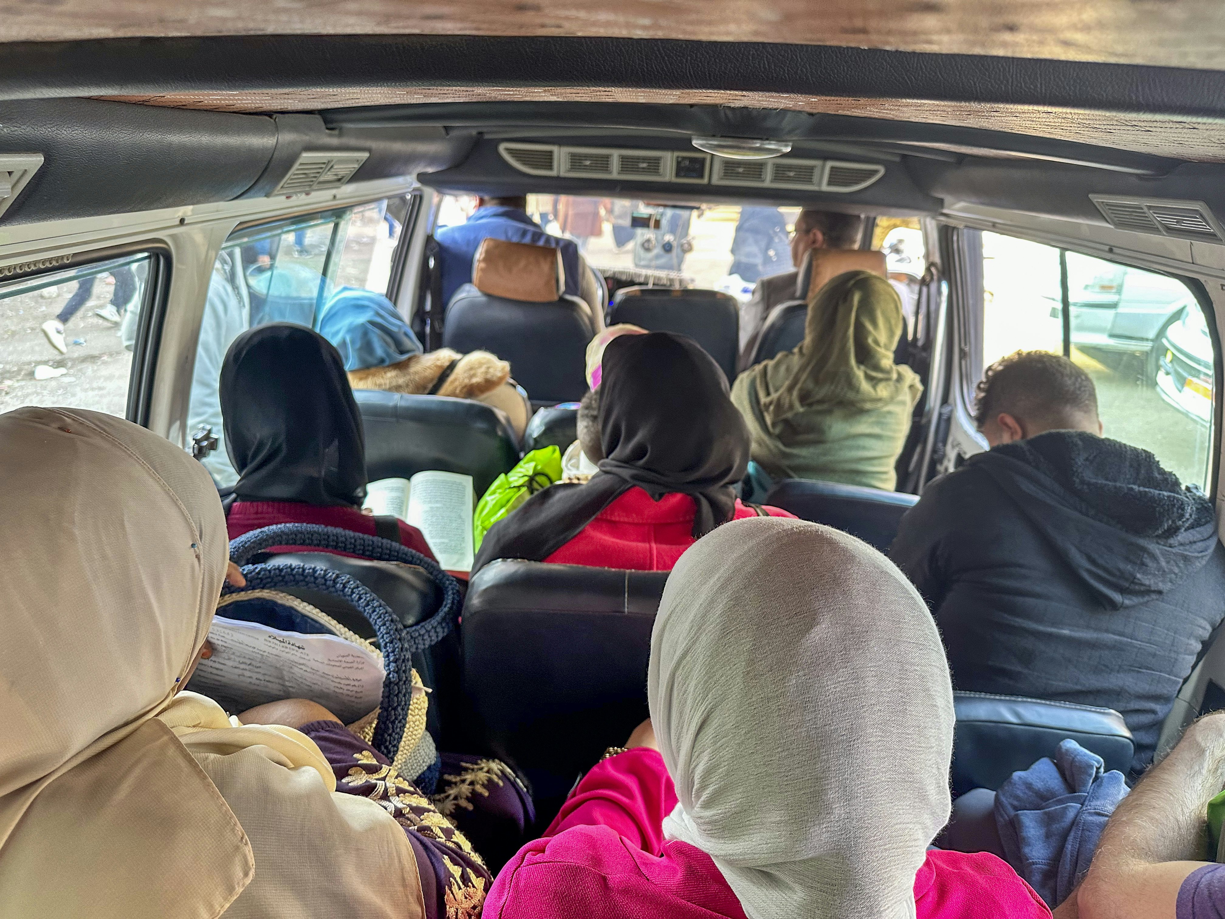 The interior of a minbus with people packed tightly in their seats