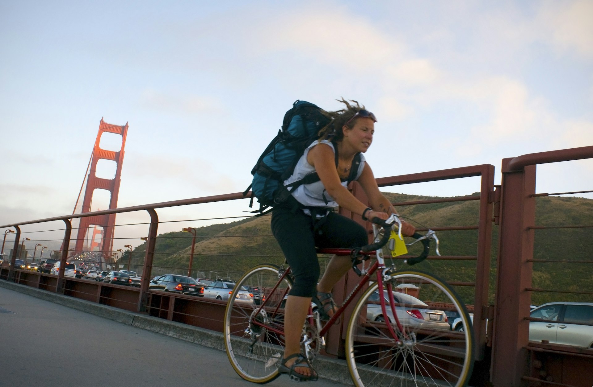 Woman riding her bike across the Golden Gate Bridge.