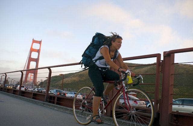 Woman riding her bike across the Golden Gate Bridge.
