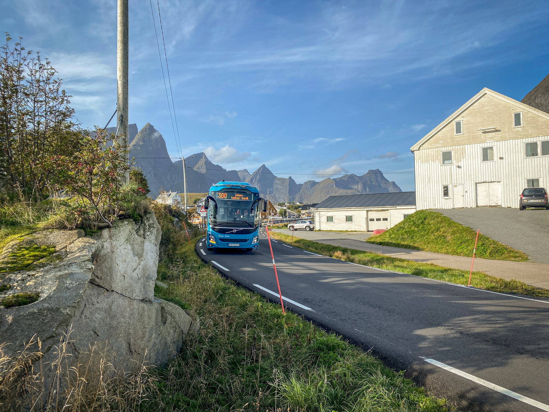 A bus passes through a lush village in Norway