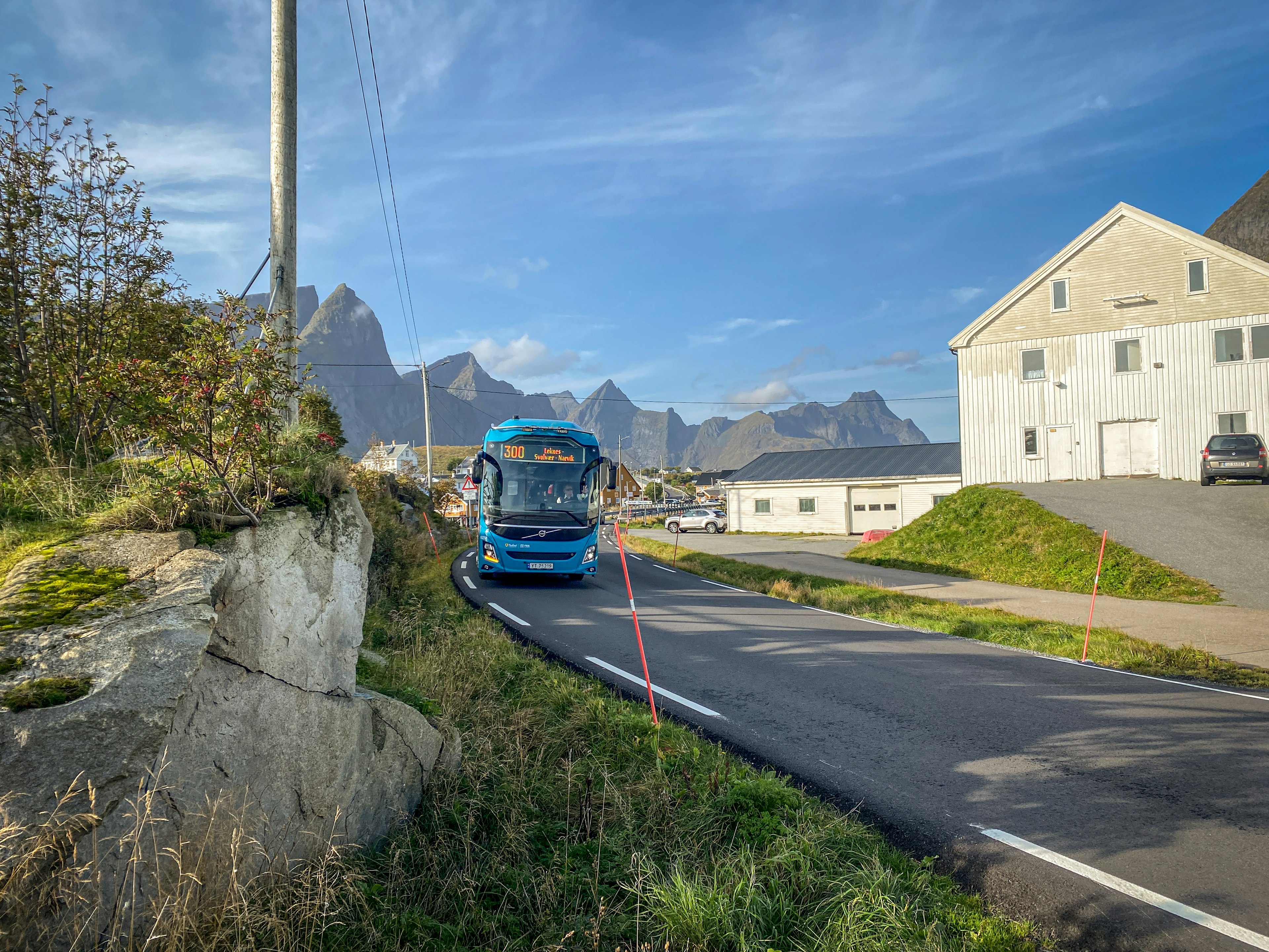 A bus passes through a lush village in Norway