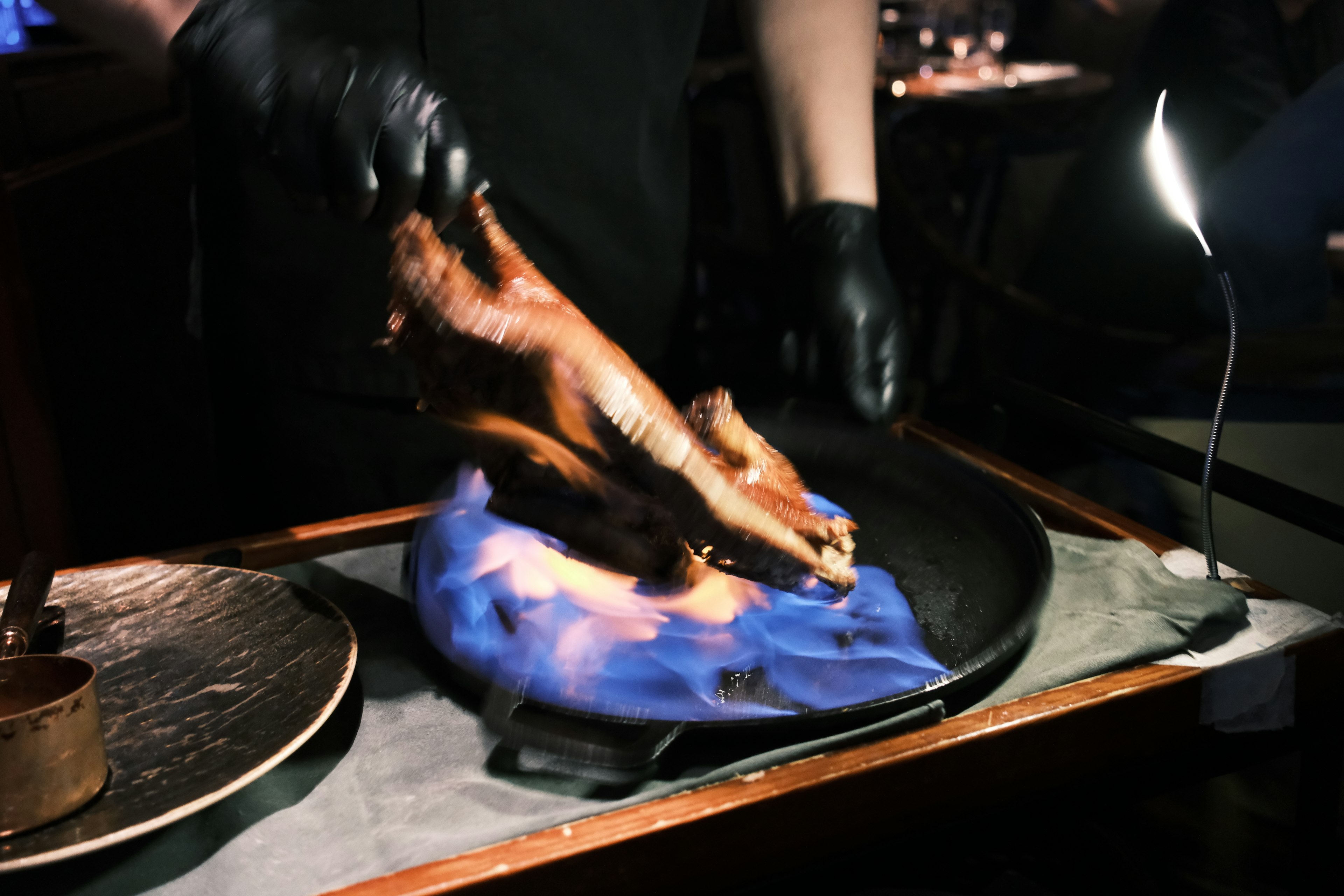 A long exposure of Peking duck being flambéd