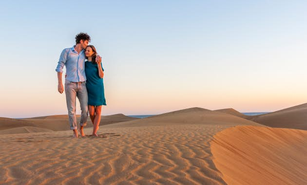 Couple walking along a sand dune