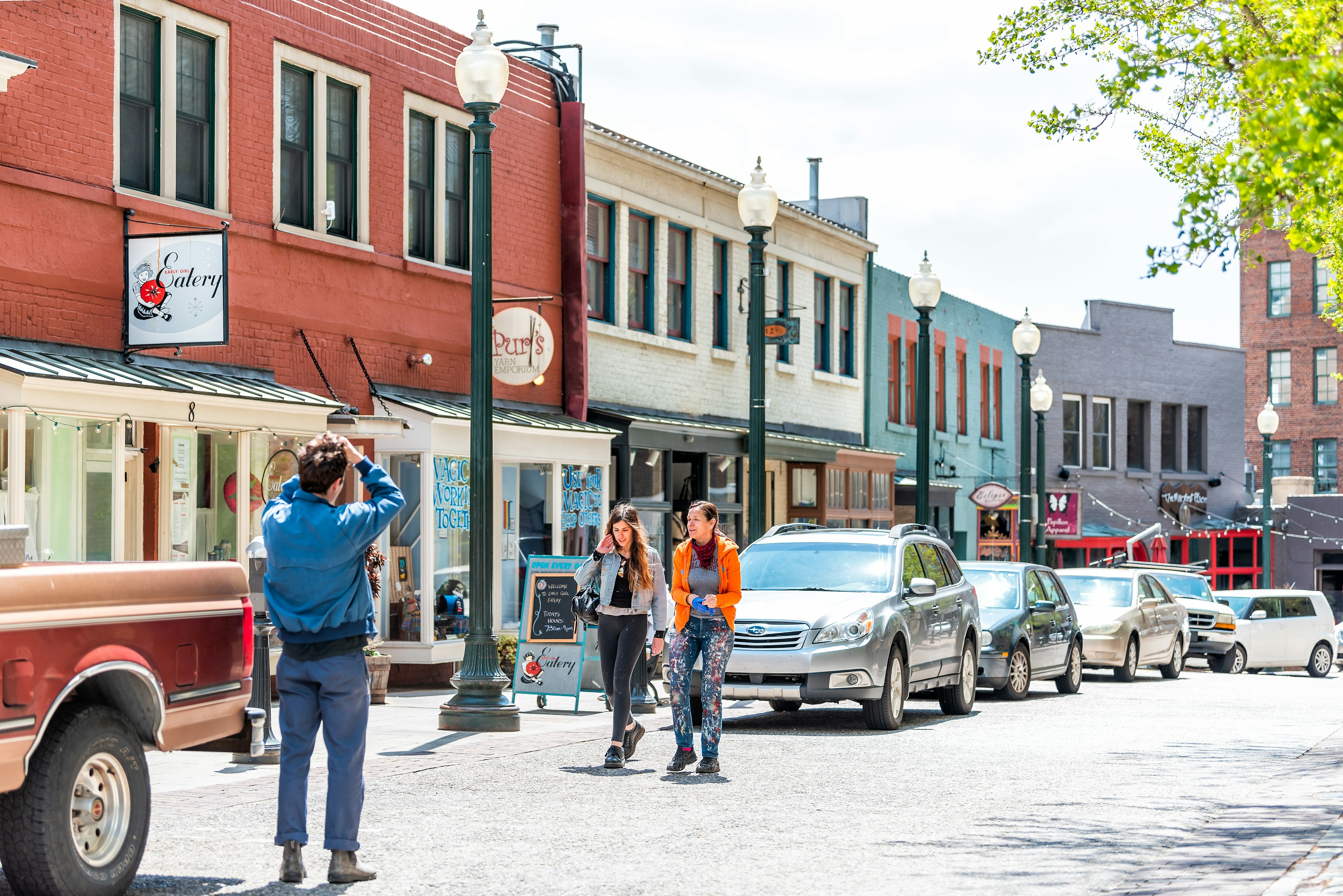 People take a picture on a side street in downtown Asheville, North Carolina, USA