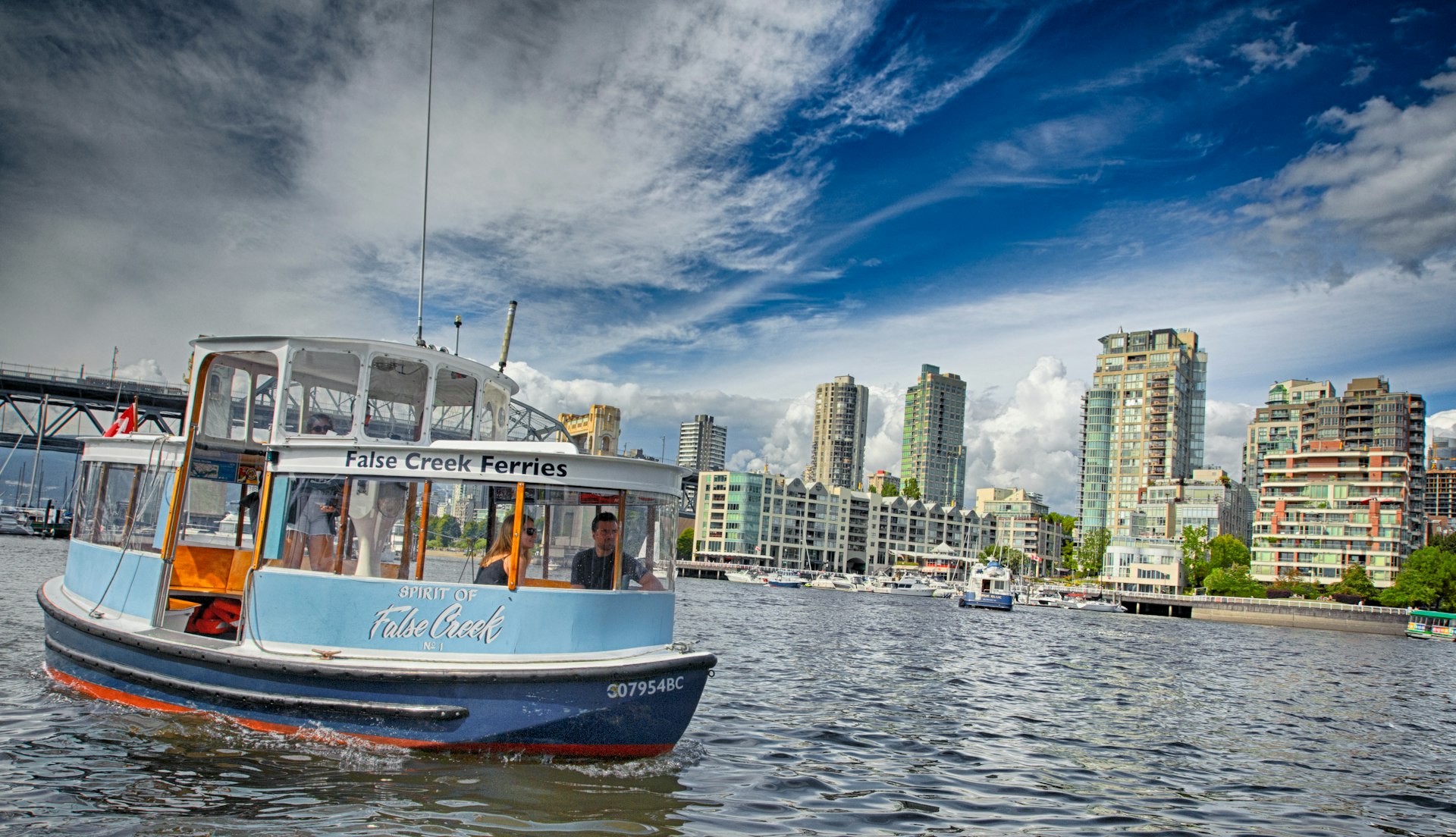 A miniferry cruises in the waterways of Vancouver on a sunny day
