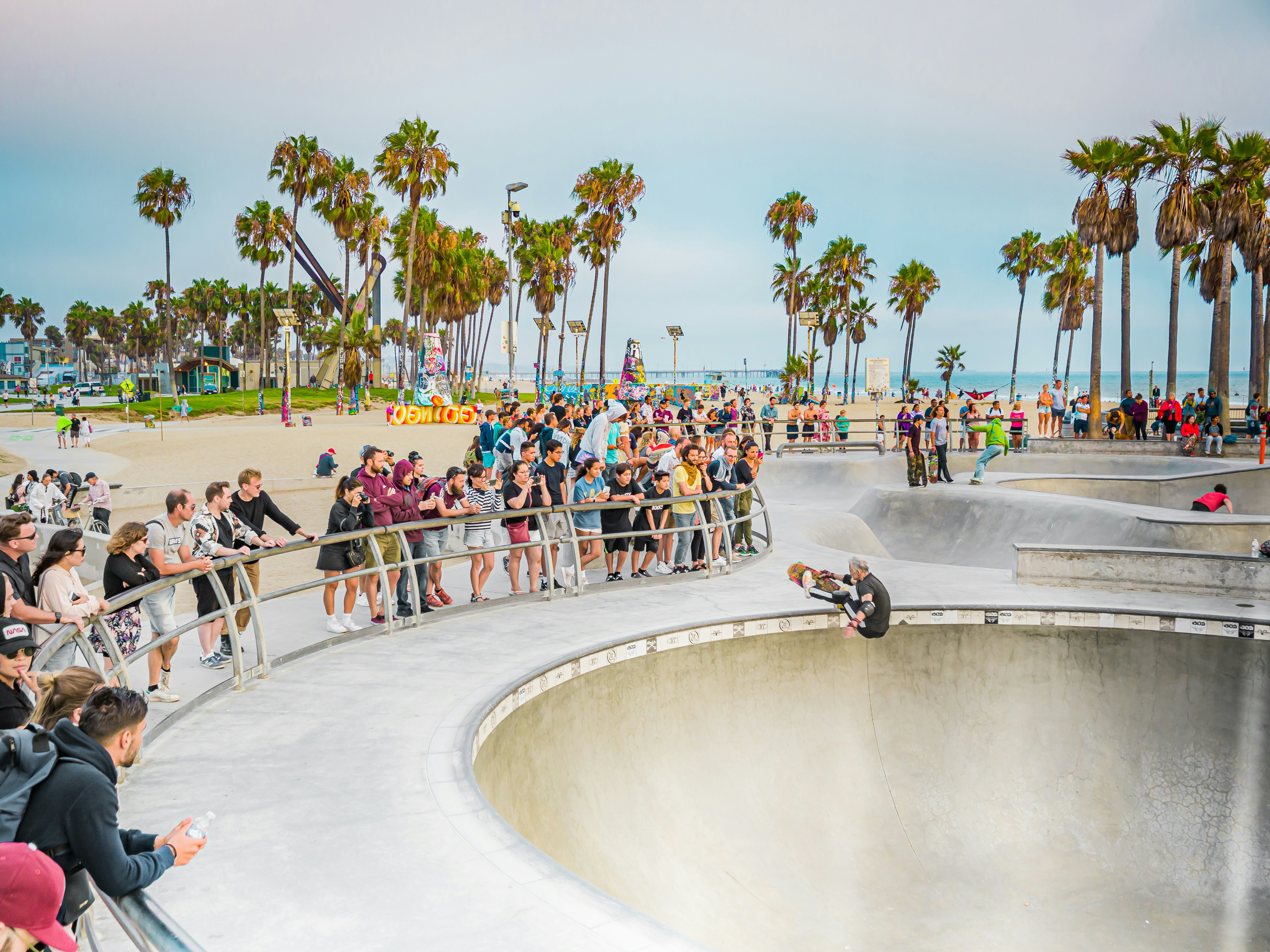 Skateboarders and onlookers at Venice Beach, Los Angeles, California, USA