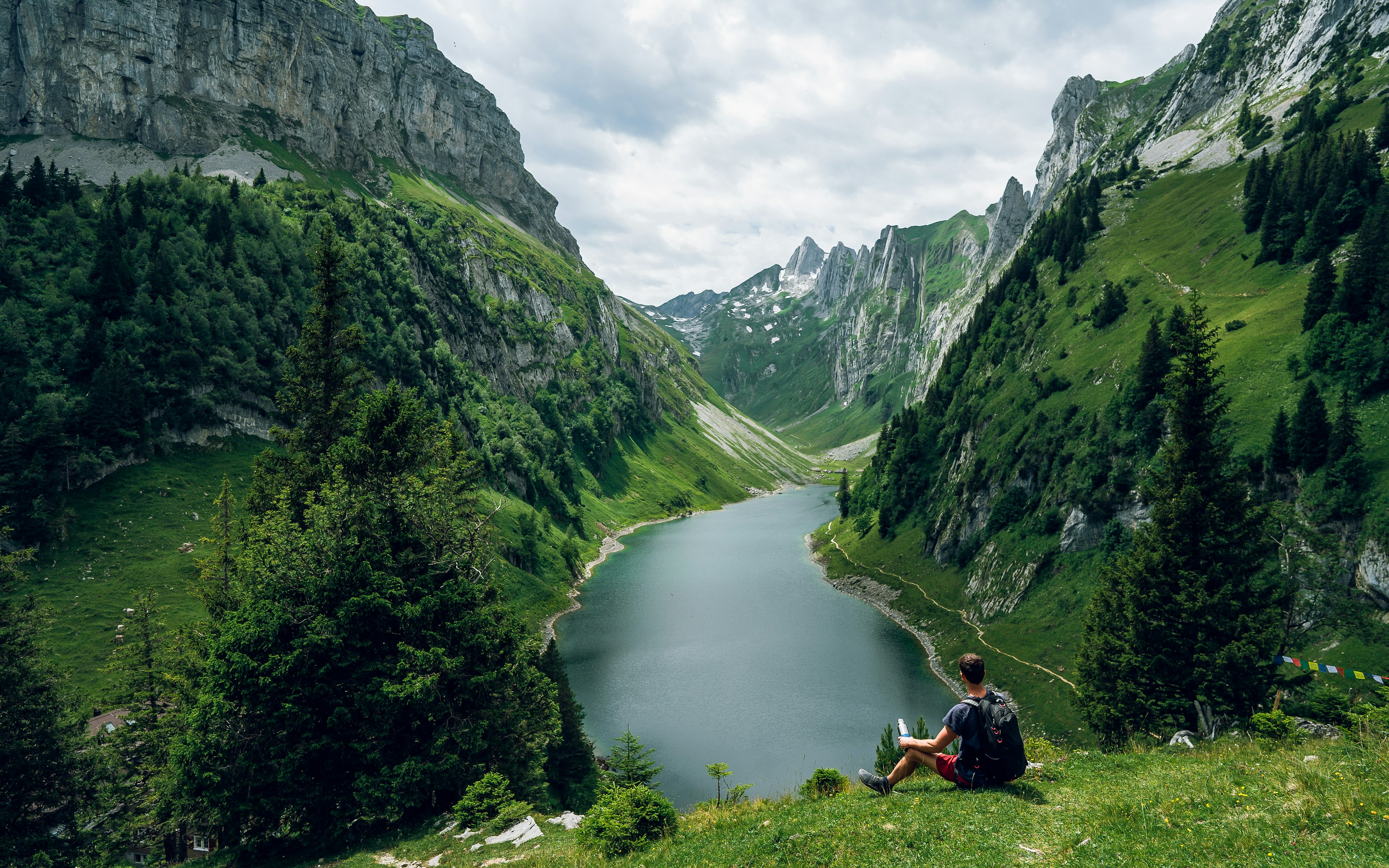 Man resting on a hike overlooking Fälensee lake in Switzerland