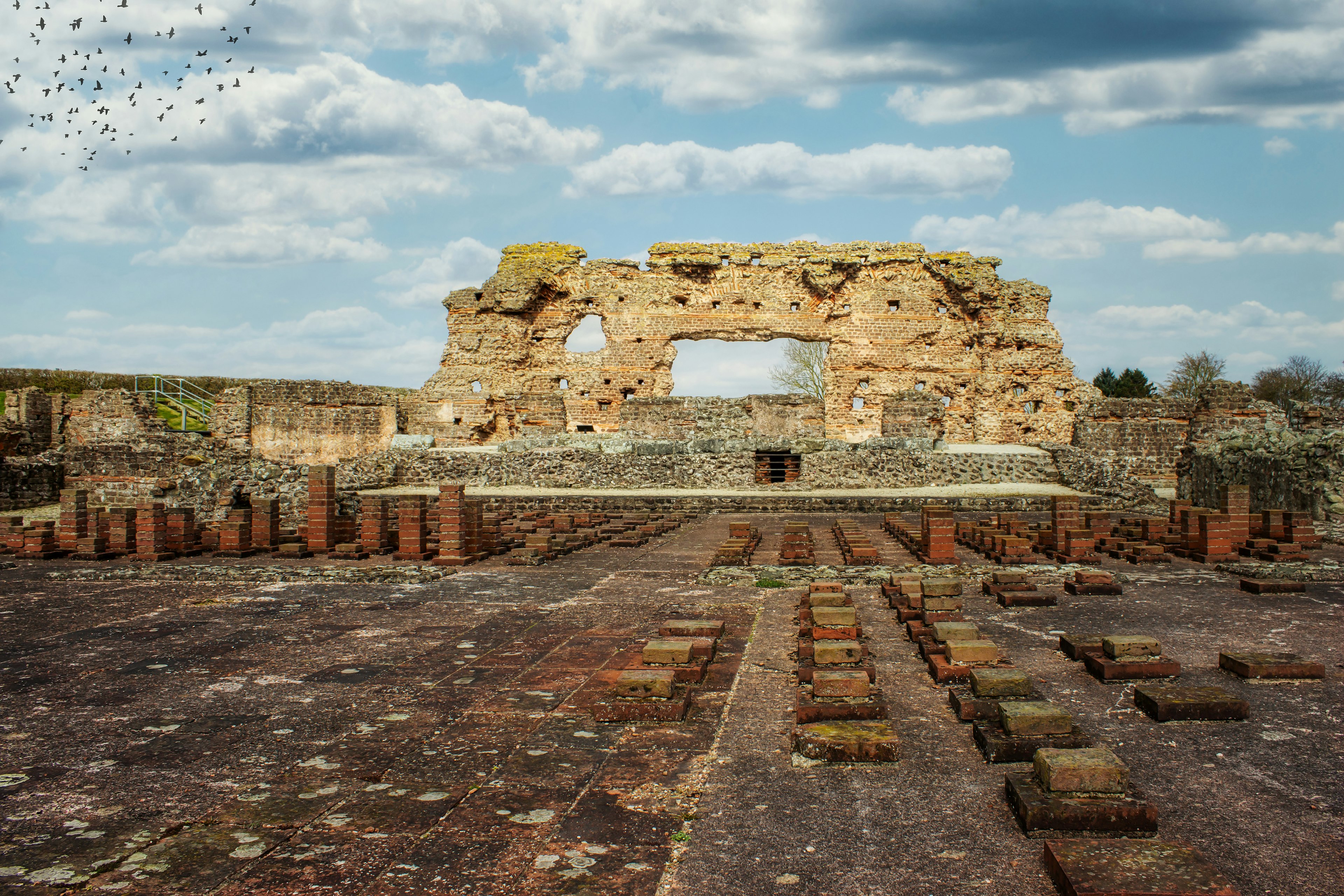 The wall of an old Roman structure stands beneath a blue sky