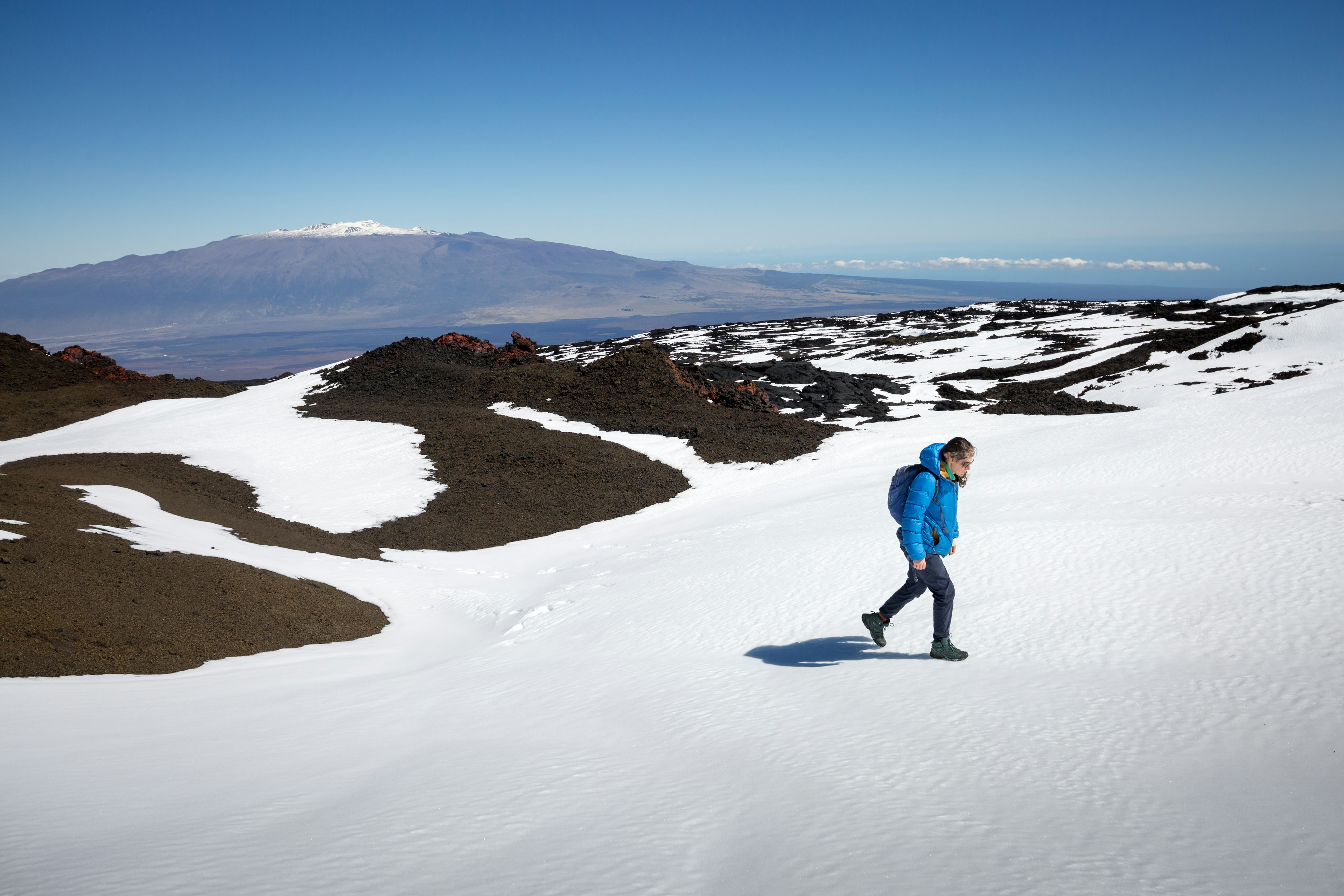 A woman hikes through snow at Hawaii Volcano National Park, Hawai‘i (the Big Island), Hawaii, USA