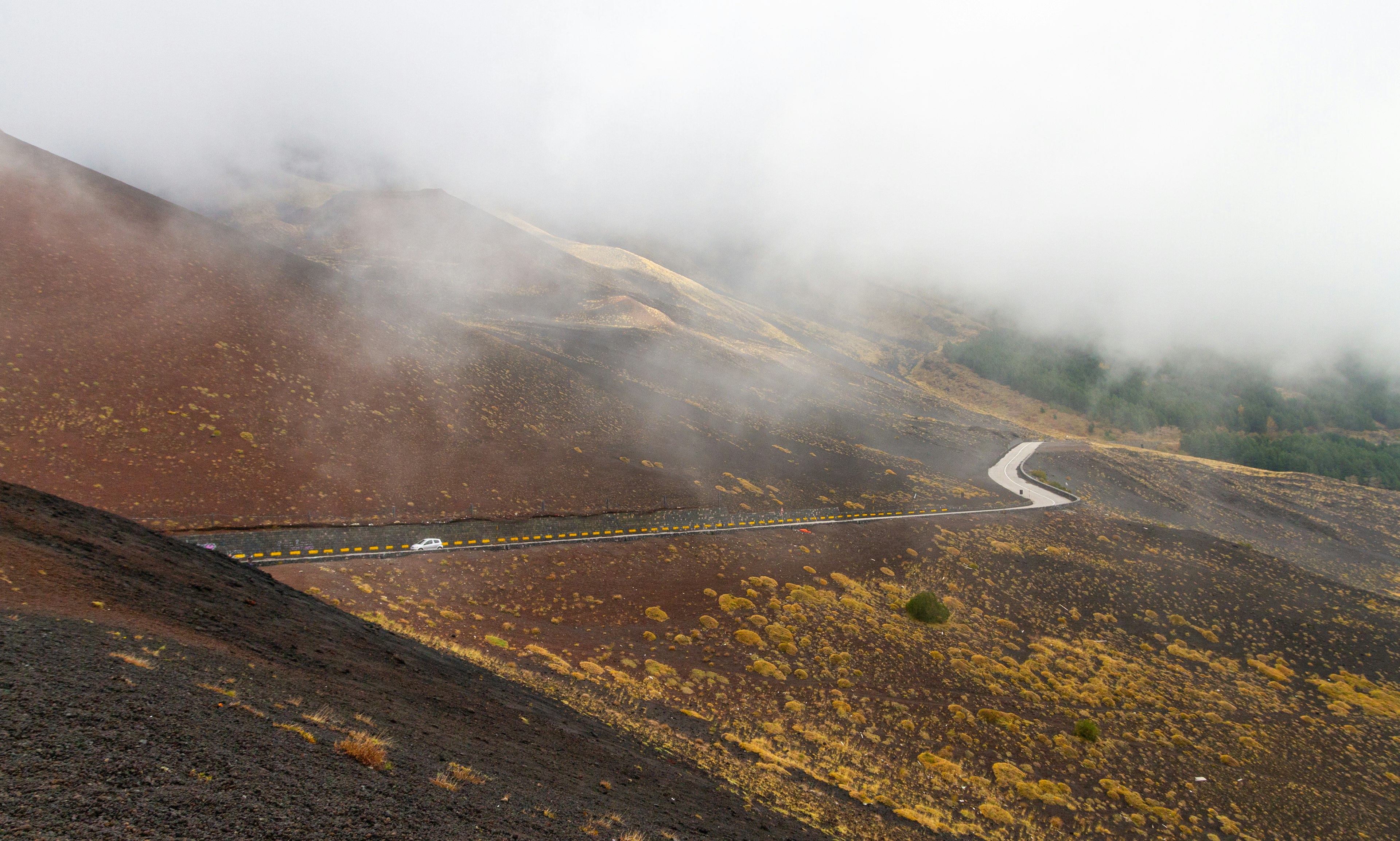 A car on an asphalt road on the way Mt Etna, Sicily, Italy