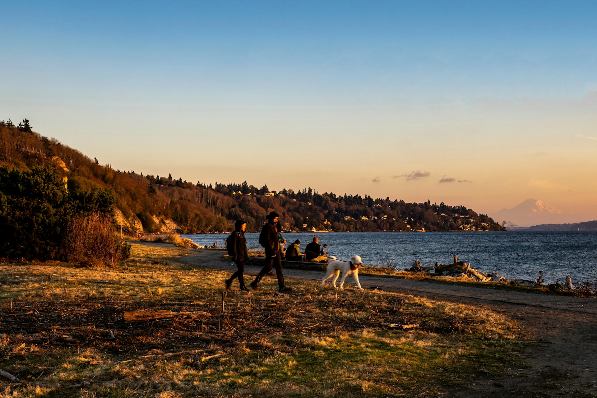 People walk on the beach at sunset at Discovery Park, Seattle