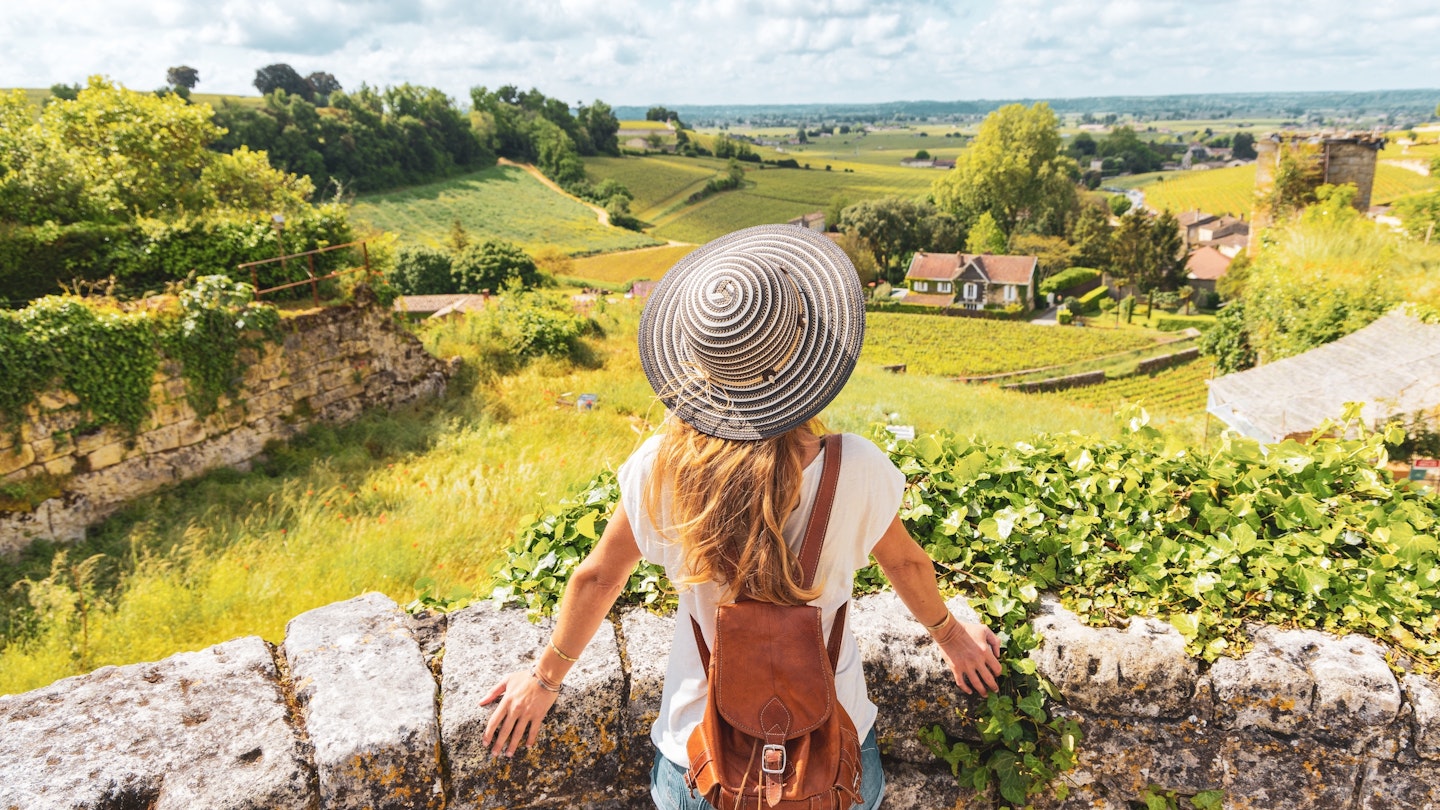 Rear view of woman looking at green vineyard in Bordeaux region, Saint Emilion- France