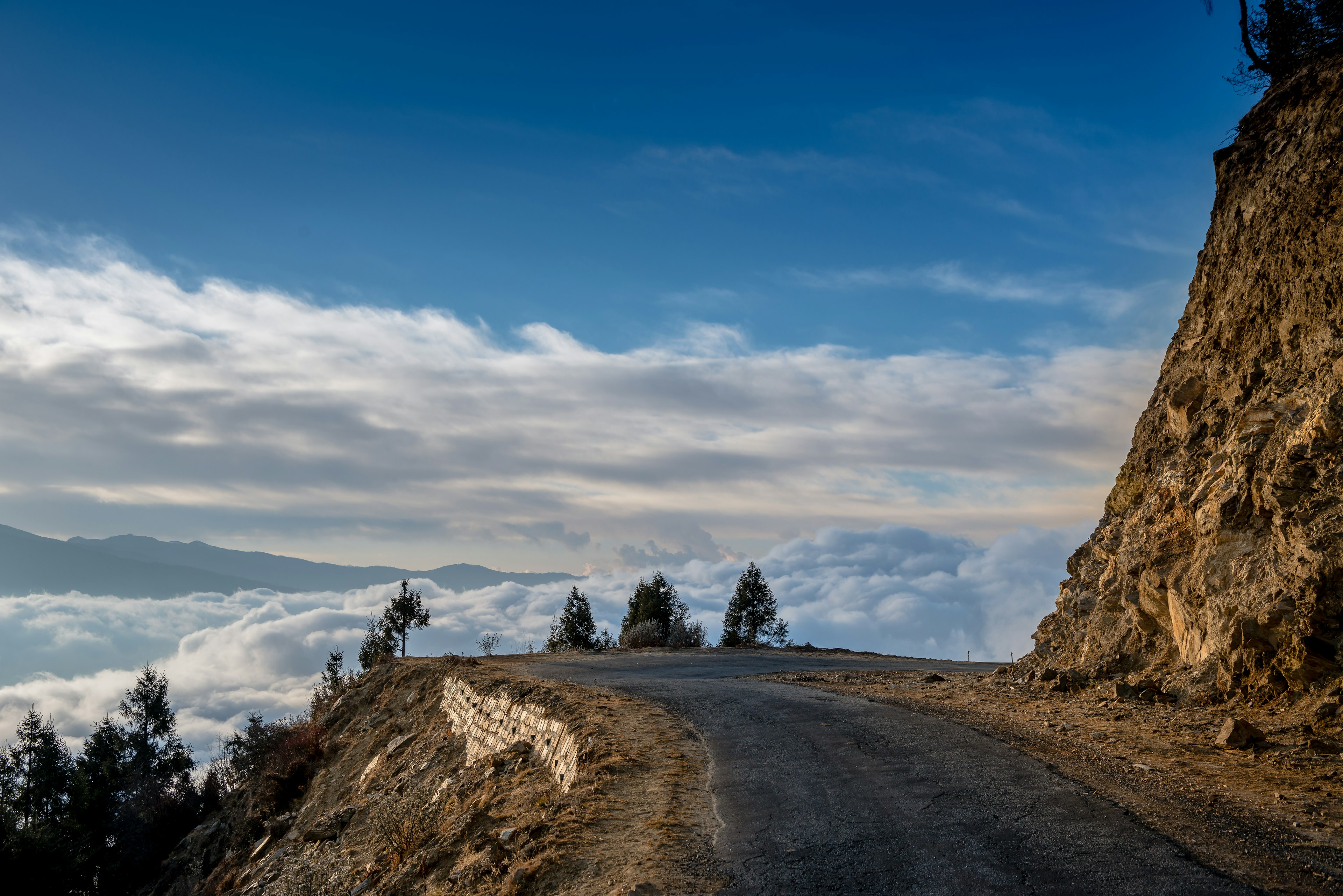 Clouds in a valley below a mountain road, Bhutan