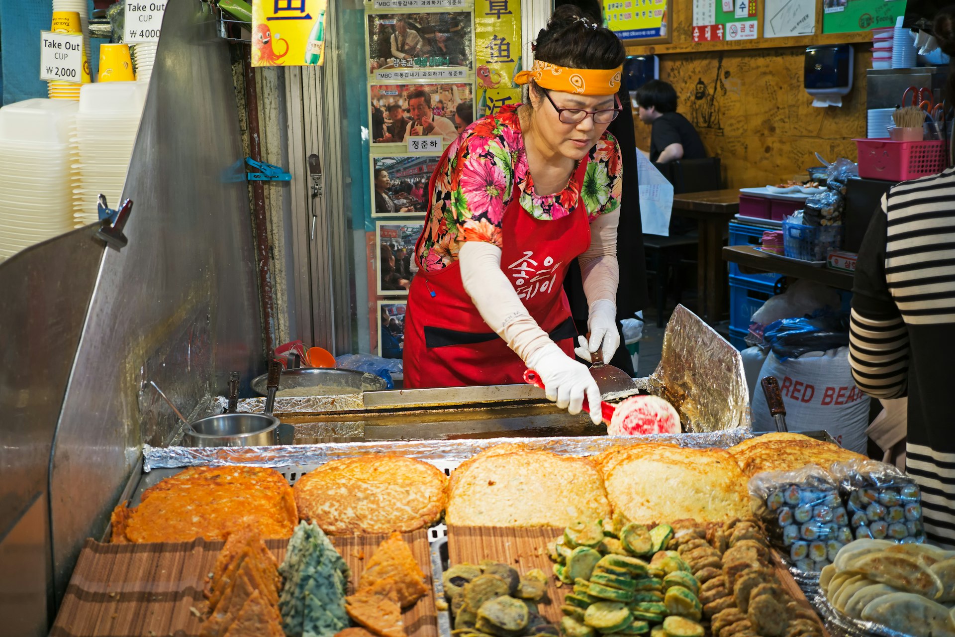 Woman vendor preparing a snack at a stall at Gwangjang Market, Seoul, South Korea