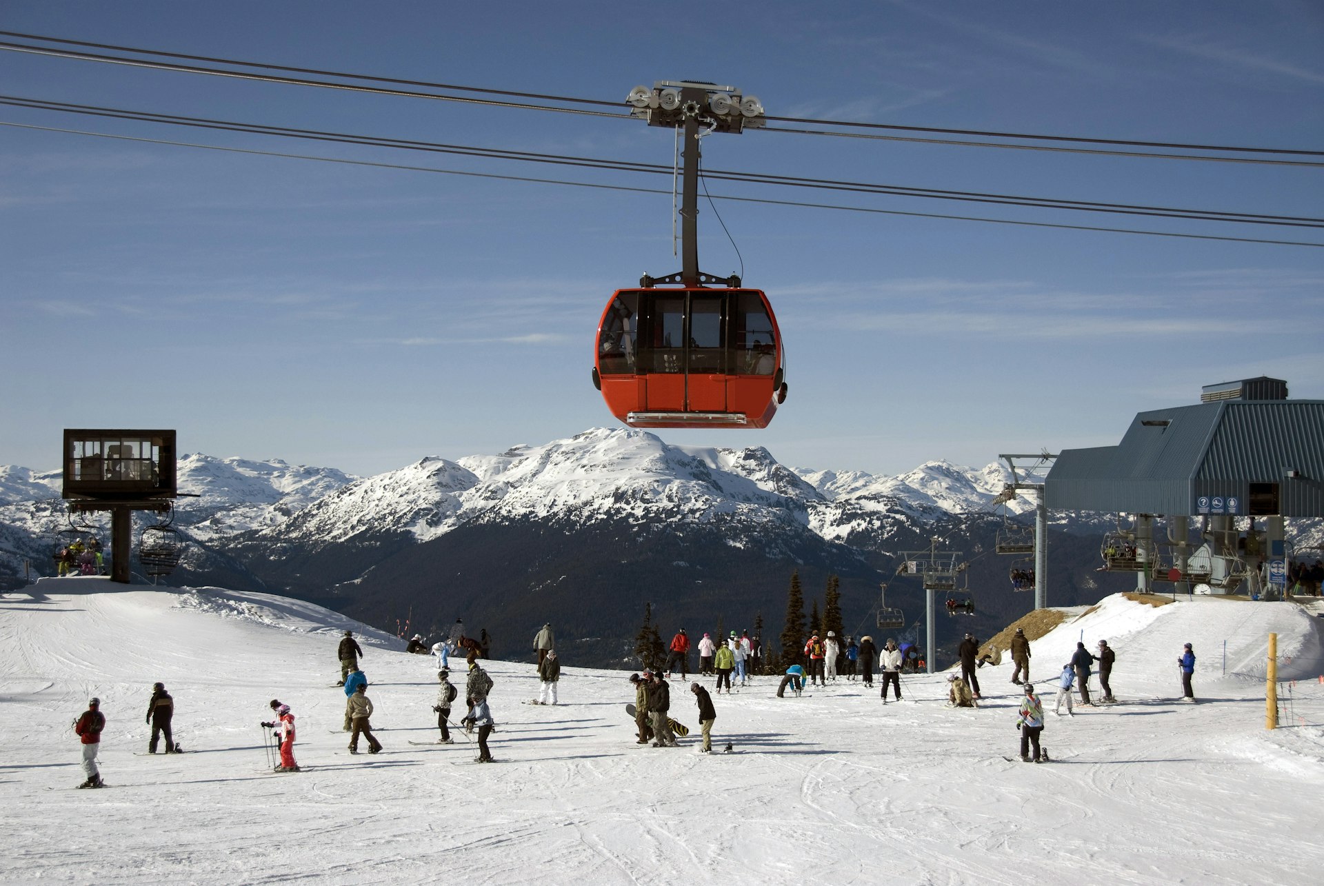 The Peak 2 Peak gondola passes over skiers on the slopes in Whistler, British Columbia, Canada