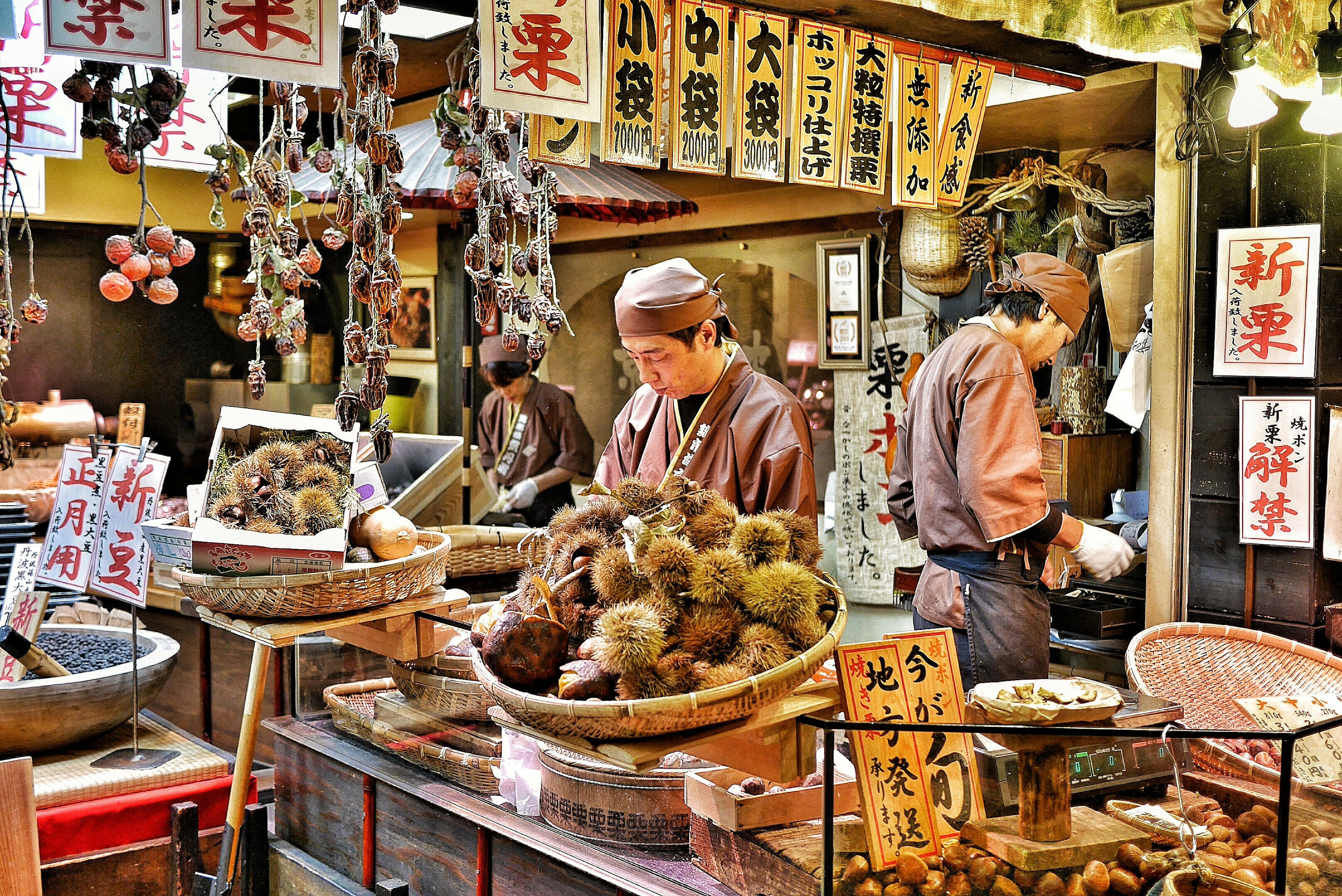 Vendors prepare chestnuts to sell at a market