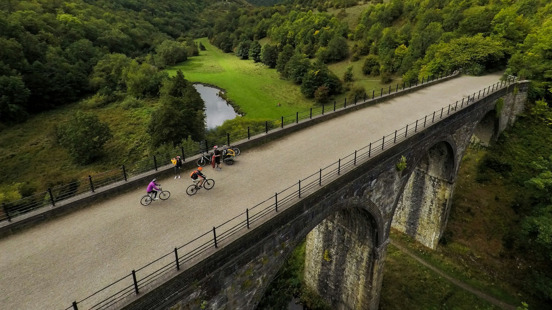 Aerial view of people riding across a viaduct in the Peak District National Park, England, United Kingdom