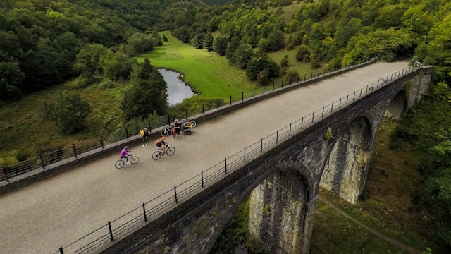 Aerial view of people riding across a viaduct in the Peak District National Park, England, United Kingdom
