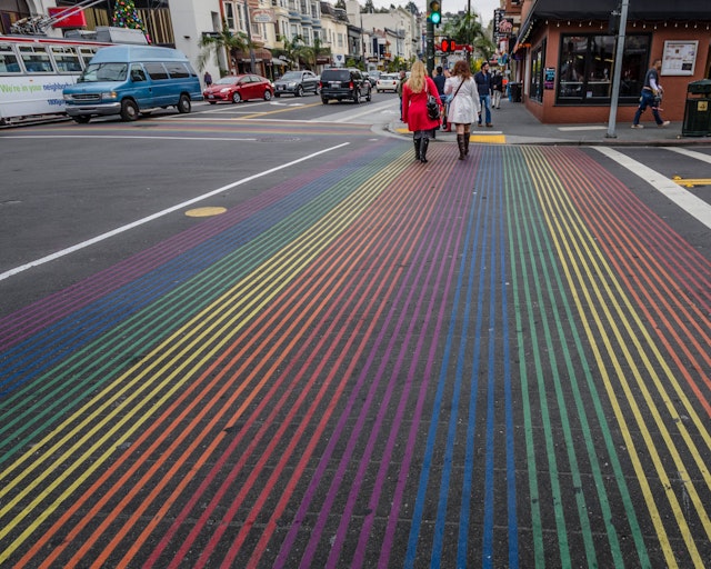 Two women cross Castro Street with its rainbow colors at 18th Street in the heart of the gay village and one of the city's most vibrant communities.