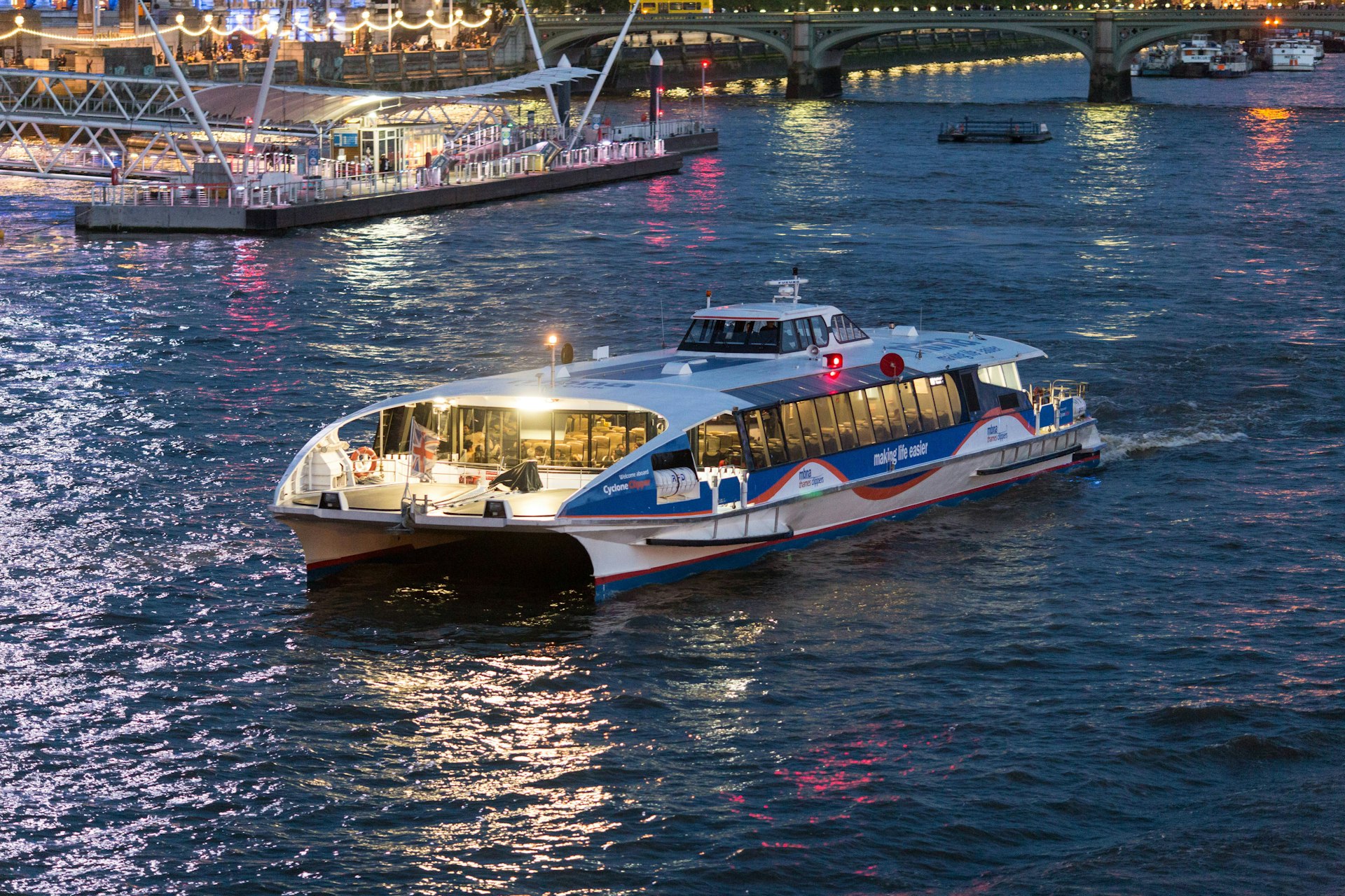 MBNA Thames Clippers departing The London Eye Waterloo Pier at night.
