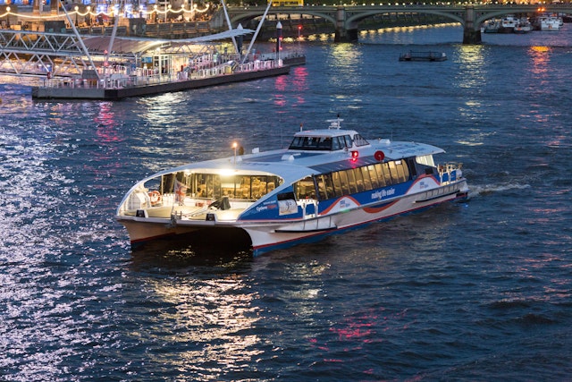 MBNA Thames Clippers departing The London Eye Waterloo Pier at night.
