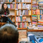 A woman reading to a small audience in an independent bookstore in San Francisco.
Getty, RFE, Adult, Book, Bookcase, Boy, Child, Clothing, Female, Footwear, Furniture, Indoors, Library, Male, Person, Publication, Shelf, Shoe, Shop, Woman