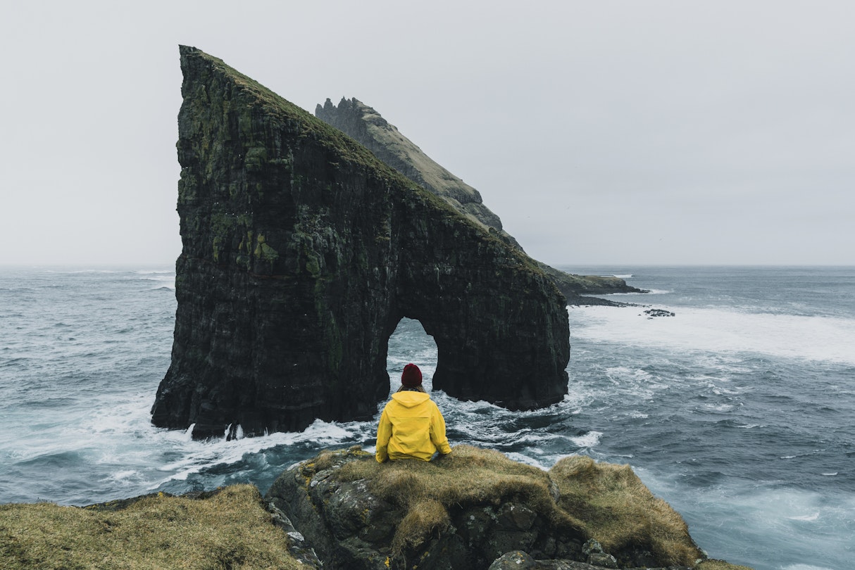Woman in yellow raincoat looking at Drangarnir arch in Faroe Islands
1133841897
scenics - nature, sea, coastline, island, rock - object, cliff, cloud - sky, landscape - scenery, atlantic ocean, beauty in nature, nature, water, mountain, panoramic, travel, idyllic, awe, extreme terrain, majestic, north, rock formation, mountain peak, wave - water, outdoors, travel destinations, vacations, hill, summer, winter, iceland, faroe islands, at the edge of, blue, arch - architectural feature, natural column, journey, distant, women, people, yellow, tourist, candid, raincoat, tranquility, looking at view, leisure activity, rear view, sitting, drangarnir
