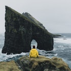 Woman in yellow raincoat looking at Drangarnir arch in Faroe Islands
1133841897
scenics - nature, sea, coastline, island, rock - object, cliff, cloud - sky, landscape - scenery, atlantic ocean, beauty in nature, nature, water, mountain, panoramic, travel, idyllic, awe, extreme terrain, majestic, north, rock formation, mountain peak, wave - water, outdoors, travel destinations, vacations, hill, summer, winter, iceland, faroe islands, at the edge of, blue, arch - architectural feature, natural column, journey, distant, women, people, yellow, tourist, candid, raincoat, tranquility, looking at view, leisure activity, rear view, sitting, drangarnir