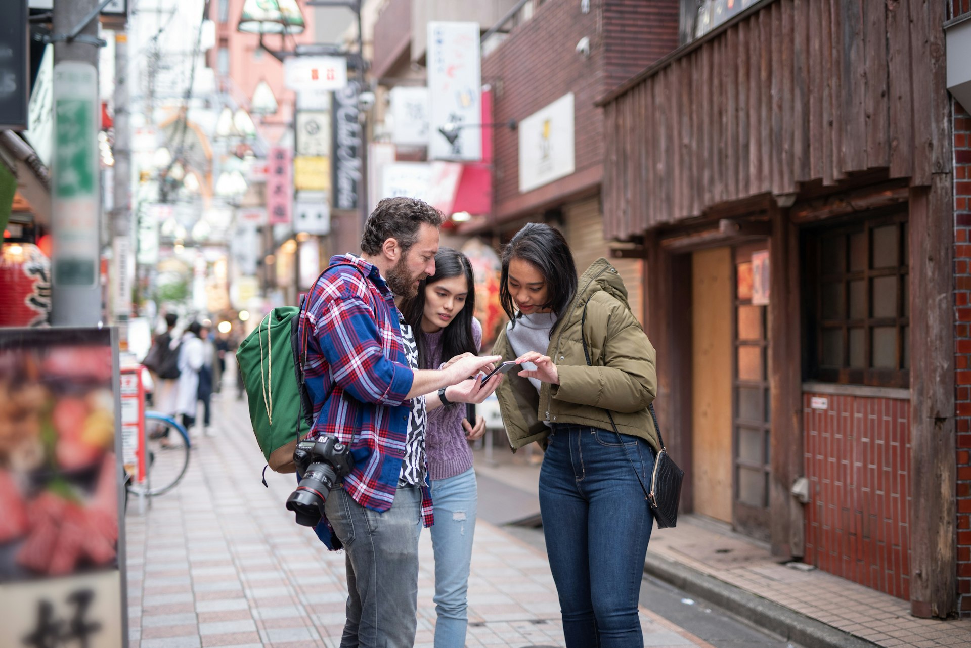 Tourists asking for directions and looking at their phones in Tokyo