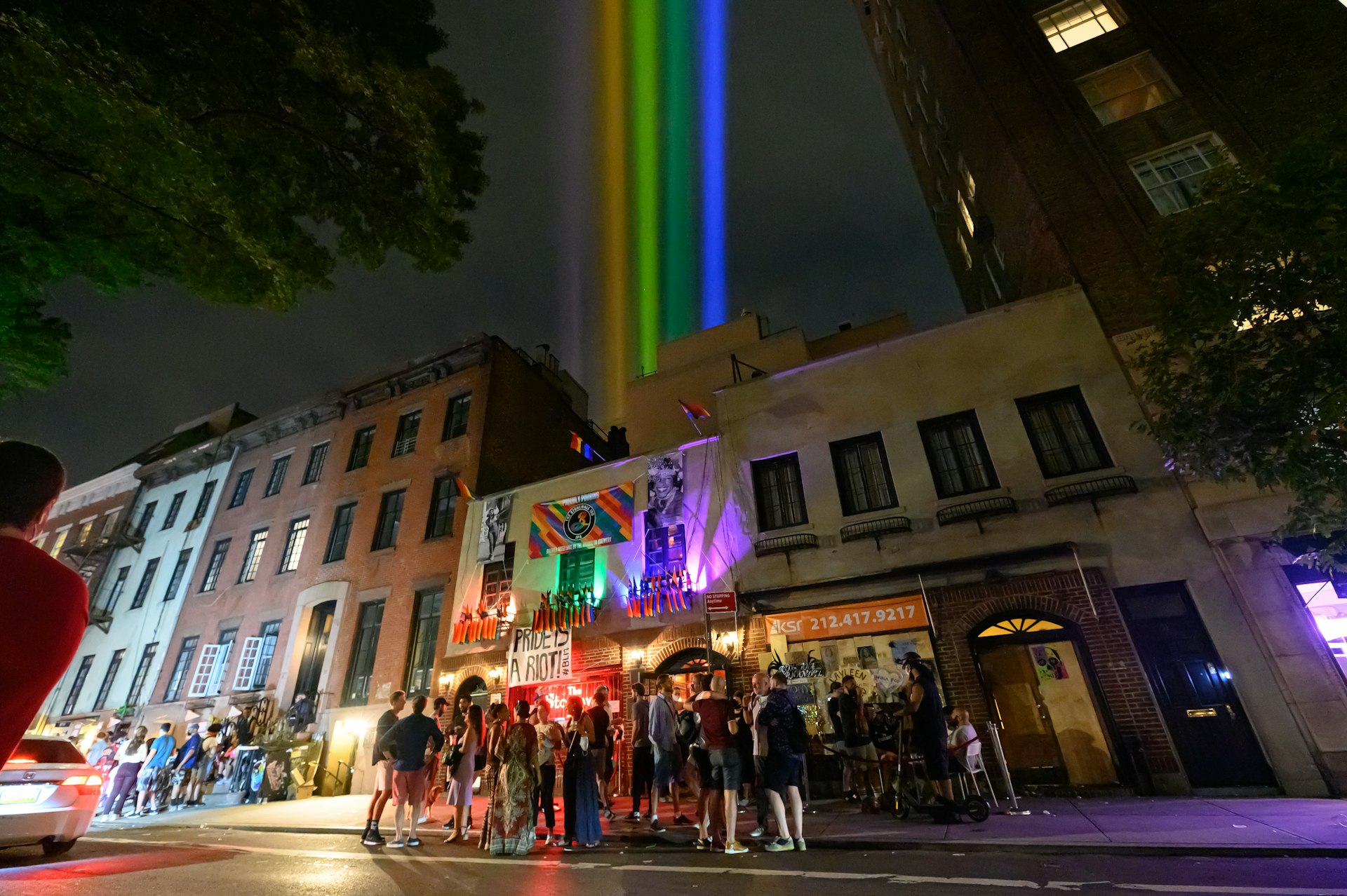 Crowds watch projected rainbow lights outside the Stonewall Inn, West Village, New York City, New York. USA