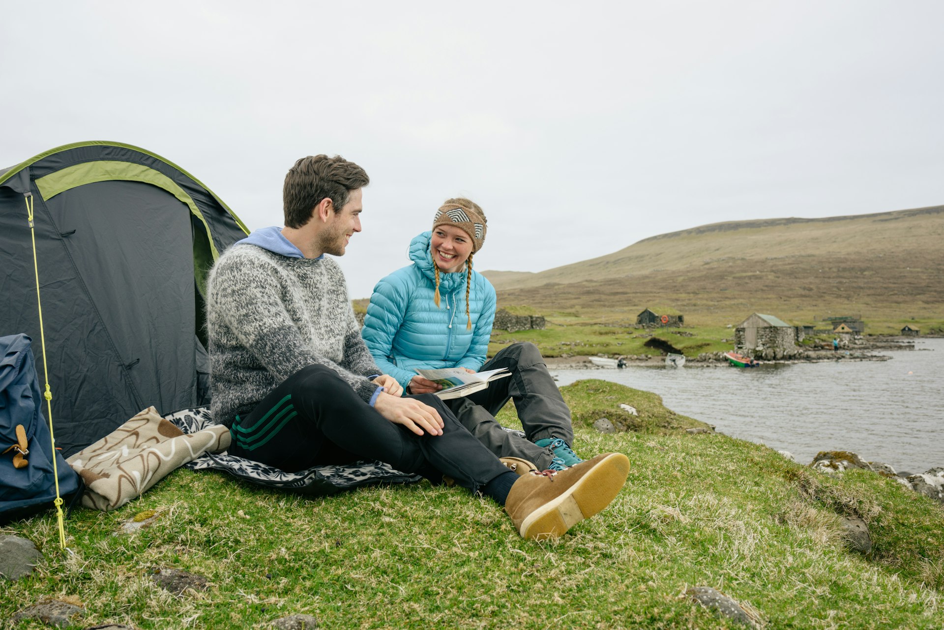 A couple laughs outside their tent in the Faroe Islands