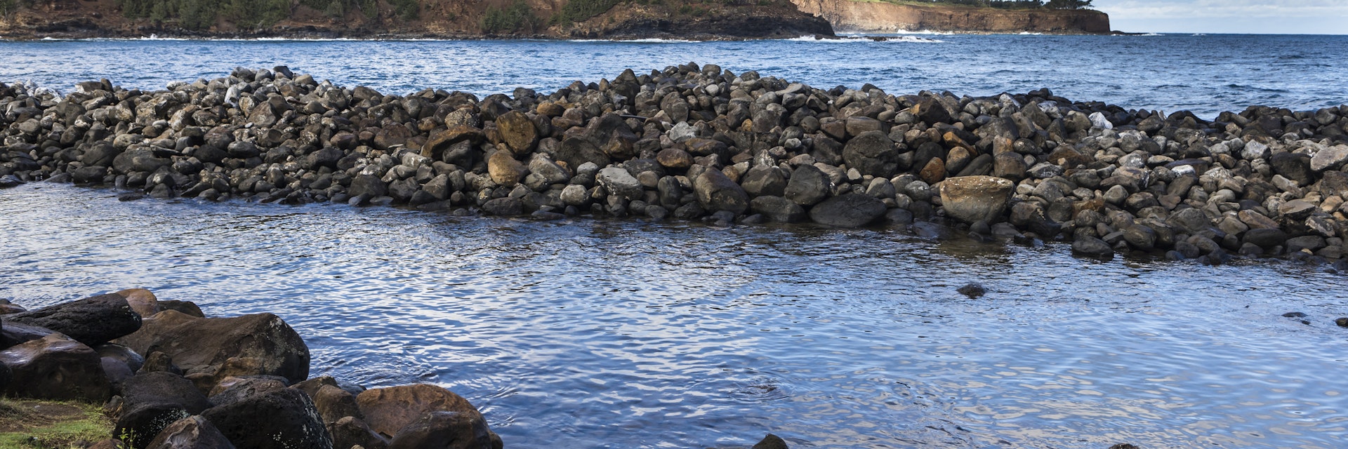 Keokea, Hawaii - December 30, 2017: View of the coastline, with a huge dock of rocks and the cliffs in the background.
1302438780