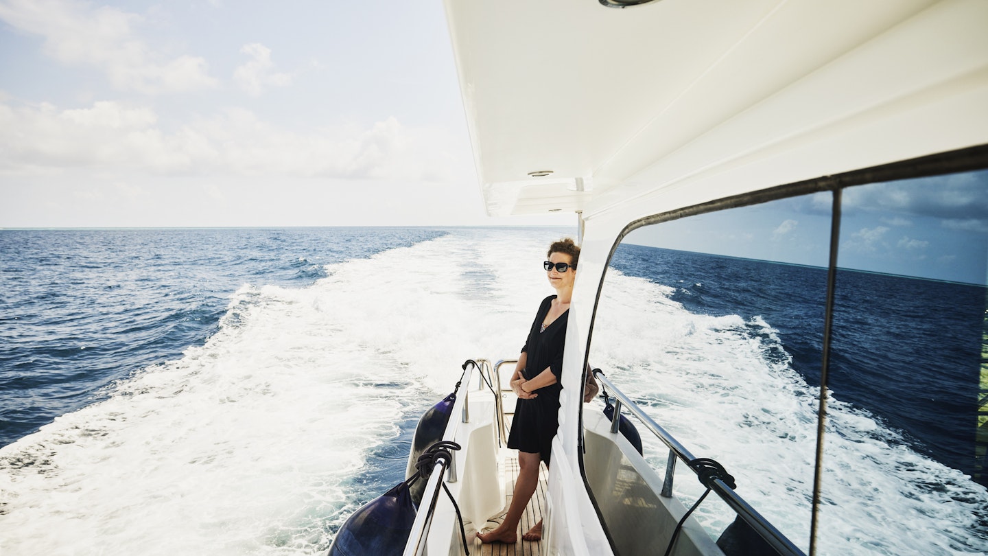 Wide shot of mature woman enjoying view while cruising on yacht in Indian Ocean in the Maldives
1392627671