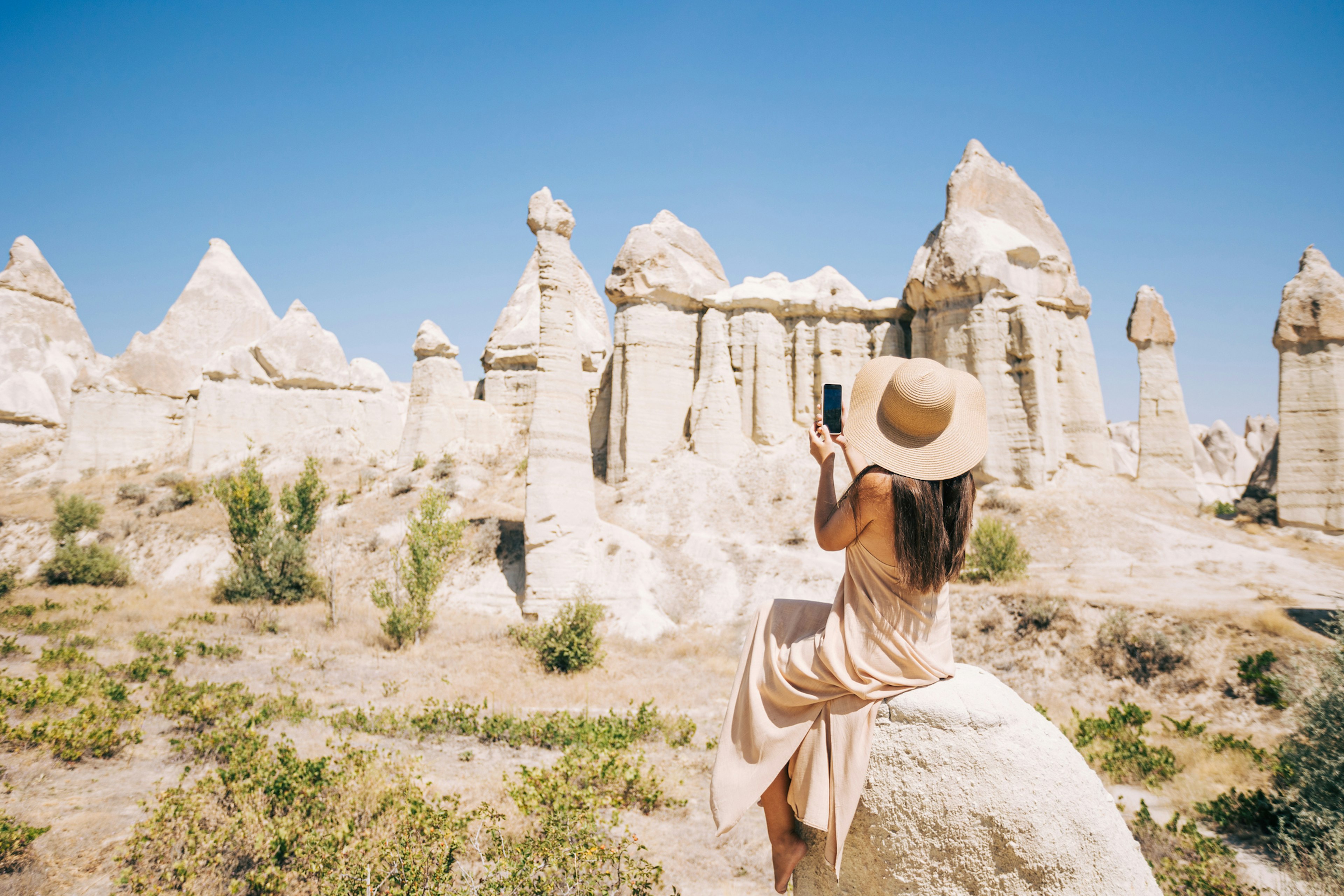 A woman taking a picture of Love Valley in Cappadocia, Turkey