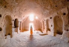 A young girl walking inside a cave church in the Zelve Ancient City at Cappadocia in Nevsehir, Turkey