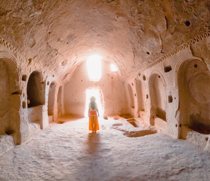 A young girl walking inside a cave church in the Zelve Ancient City at Cappadocia in Nevsehir, Turkey