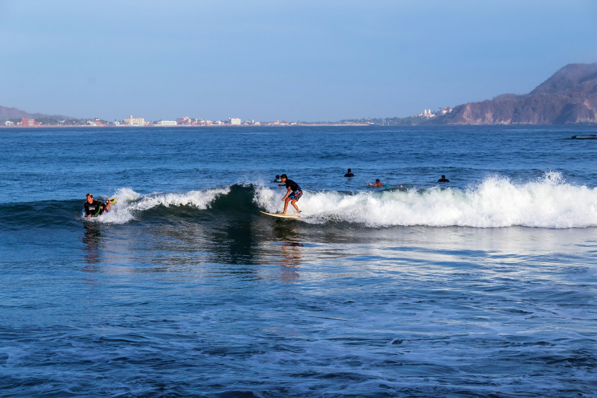 Guys enjoying the sun, surfing in Melaque beach, summer, Jalisco, México
