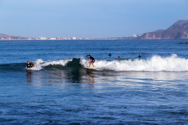Guys enjoying the sun, surfing in Melaque beach, summer, Jalisco, México