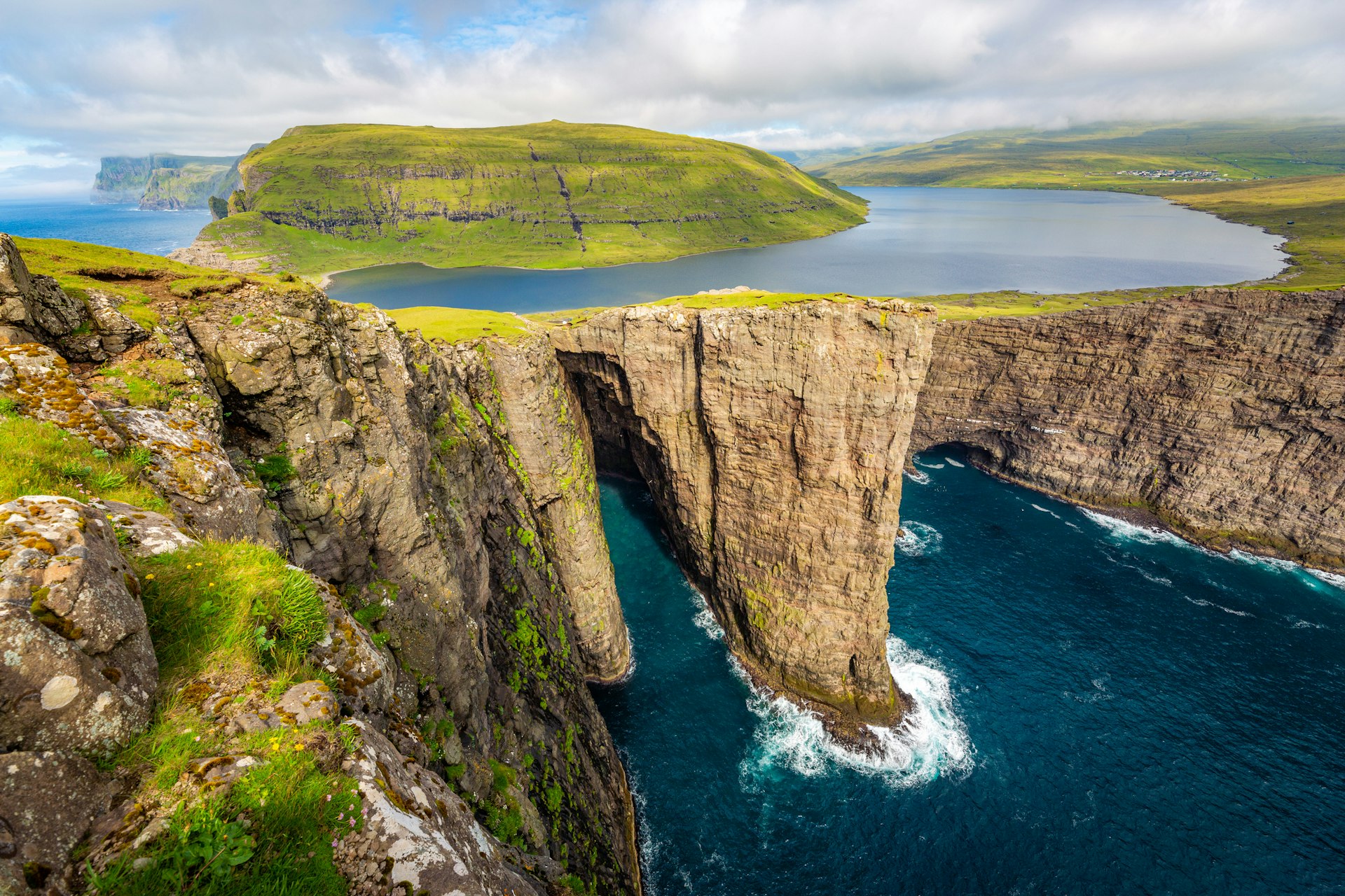 A cliff top lake appears to float above the land and ocean below