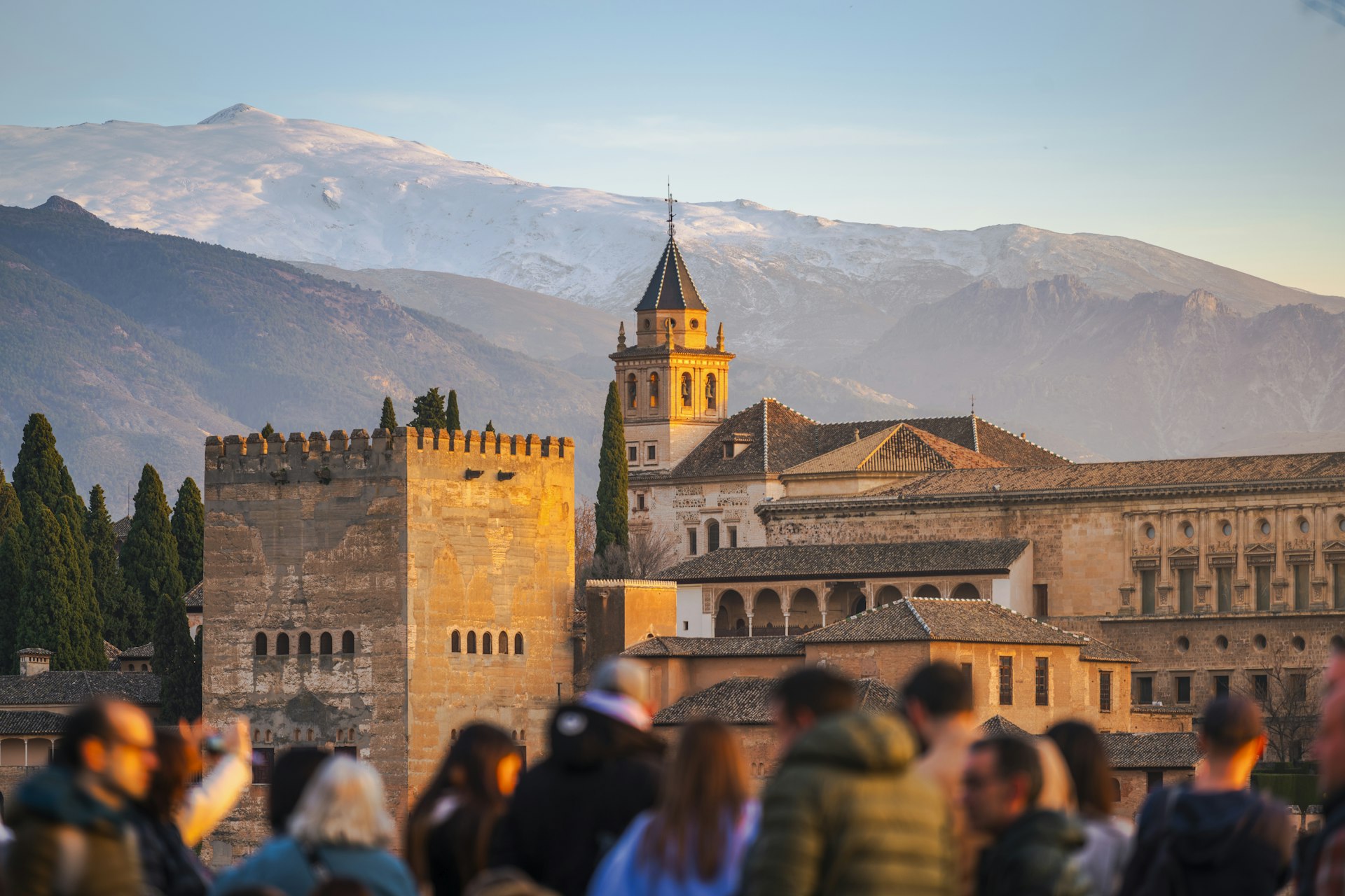 A crowd of tourists admires the Alhambra at sunset, Granada, Andalucía, Spain