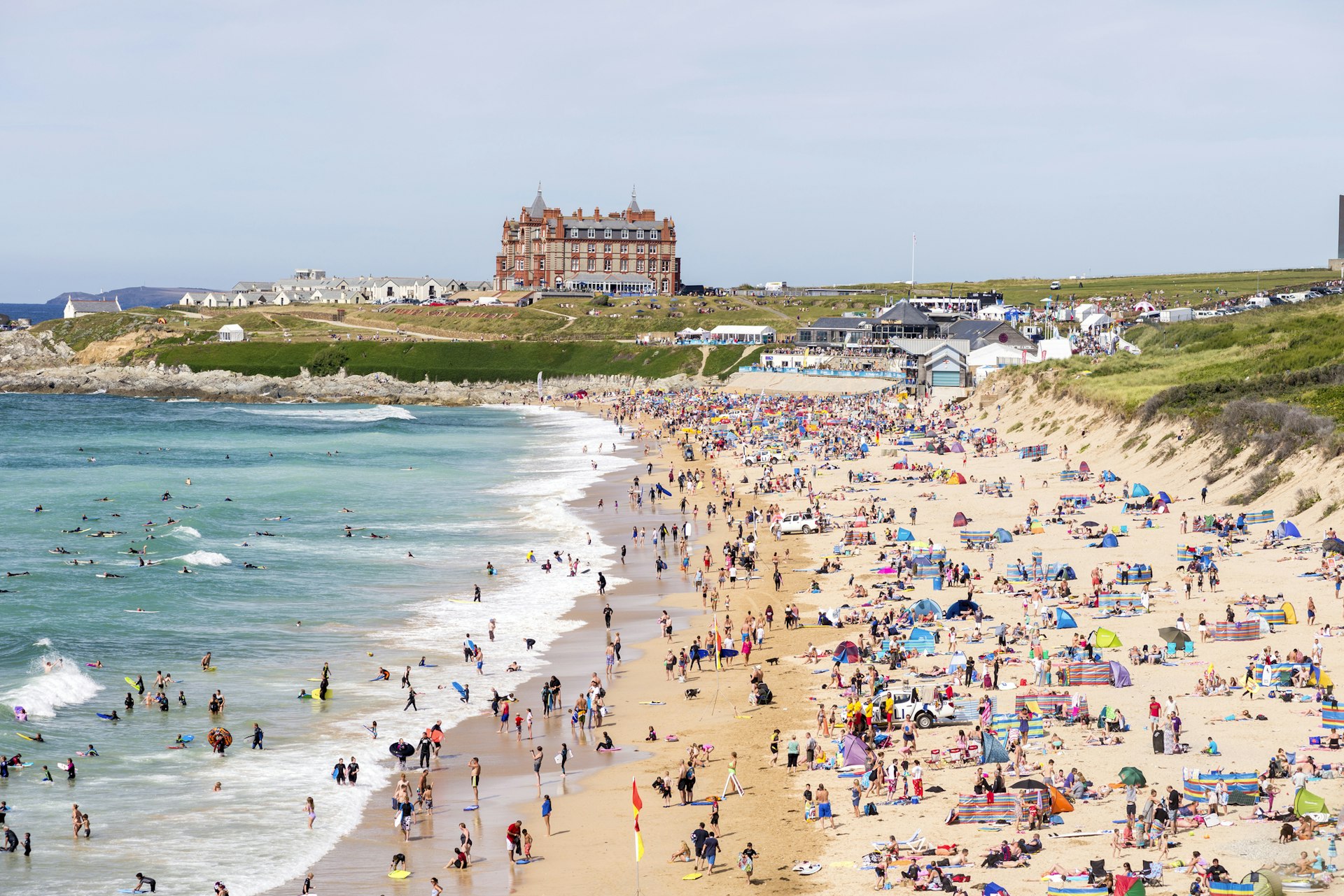 Sunbathers and surfers enjoy the beach during a sunny summer's day in Cornwall.