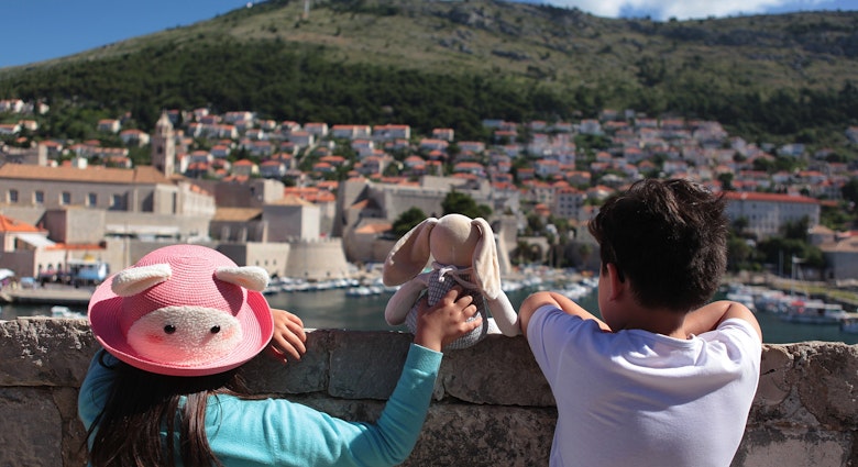 Sibling and their stuffed toy are admiring the beautiful townscape of Dubrovnik from the city wall.
672798878